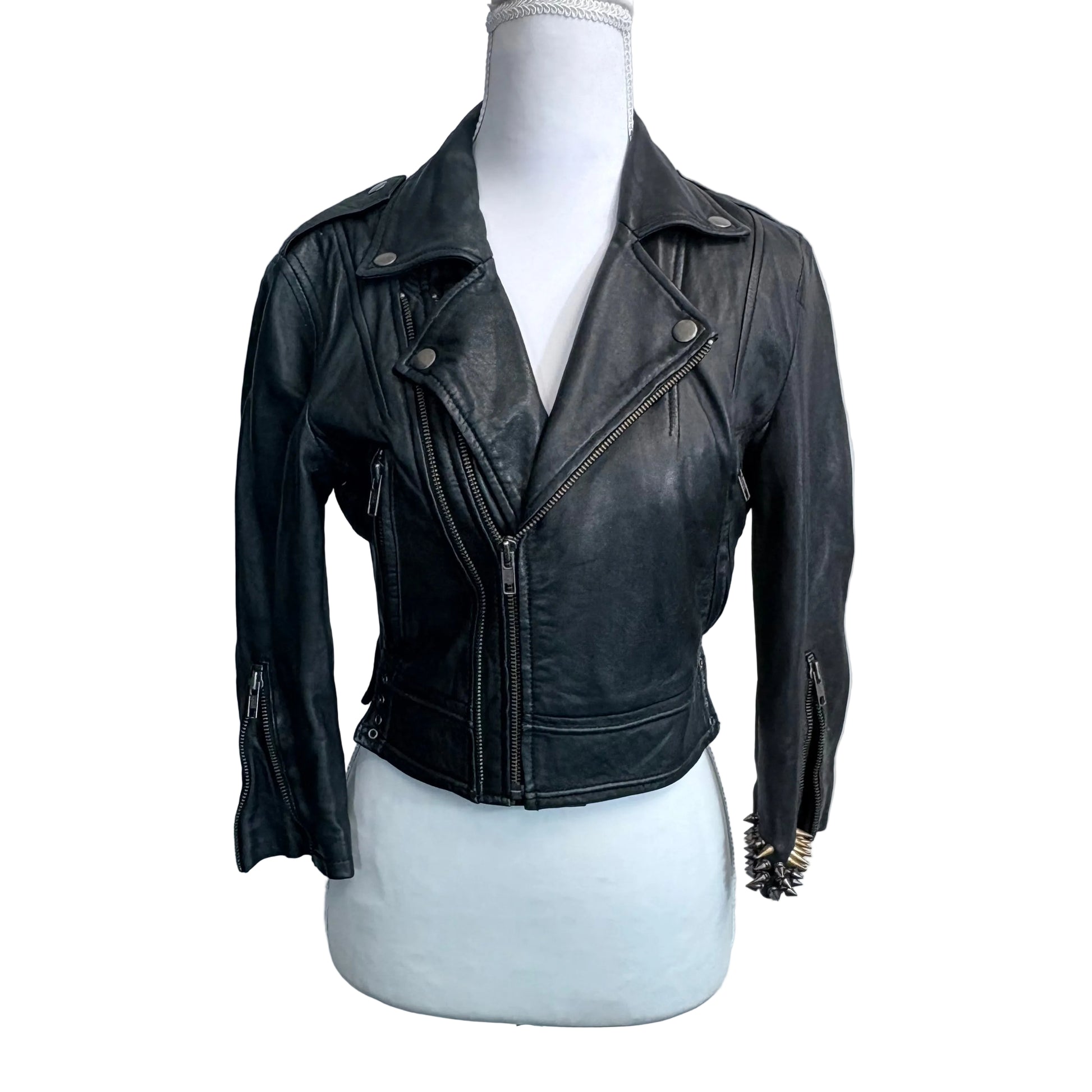 Black leather jacket on a mannequin against a plain background