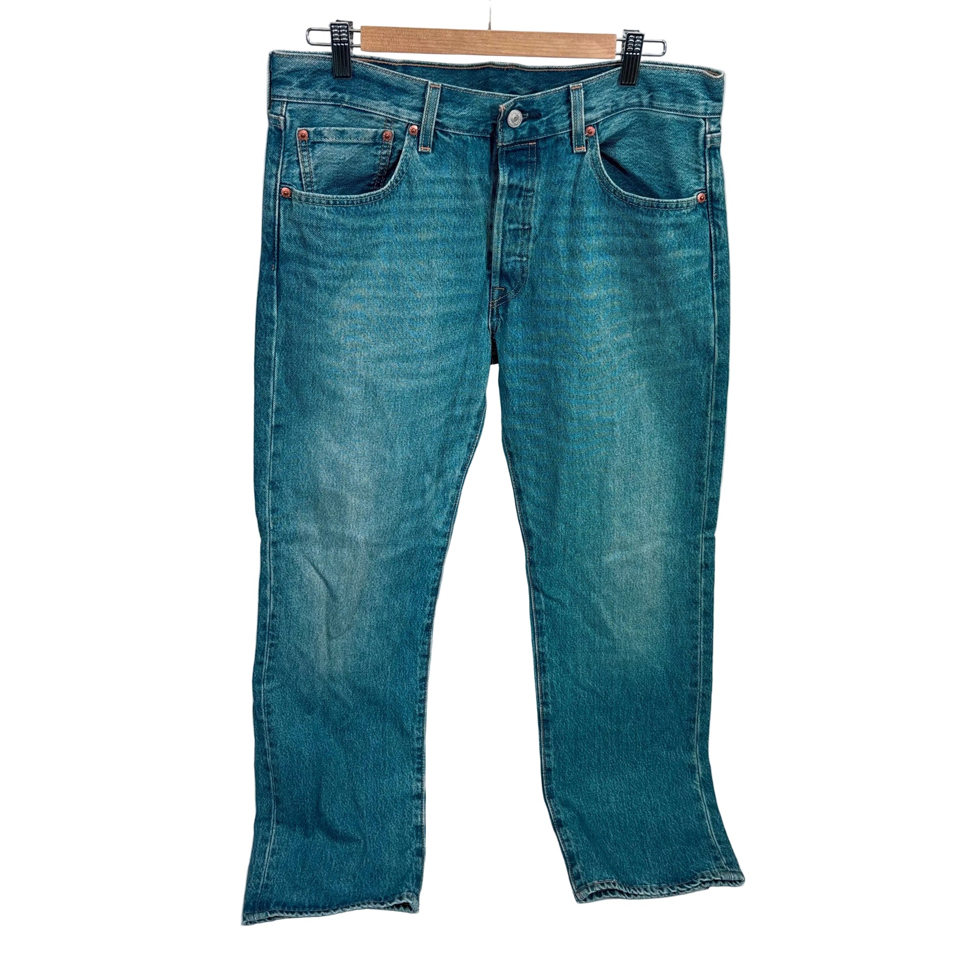 Blue jeans on a hanger against a white background