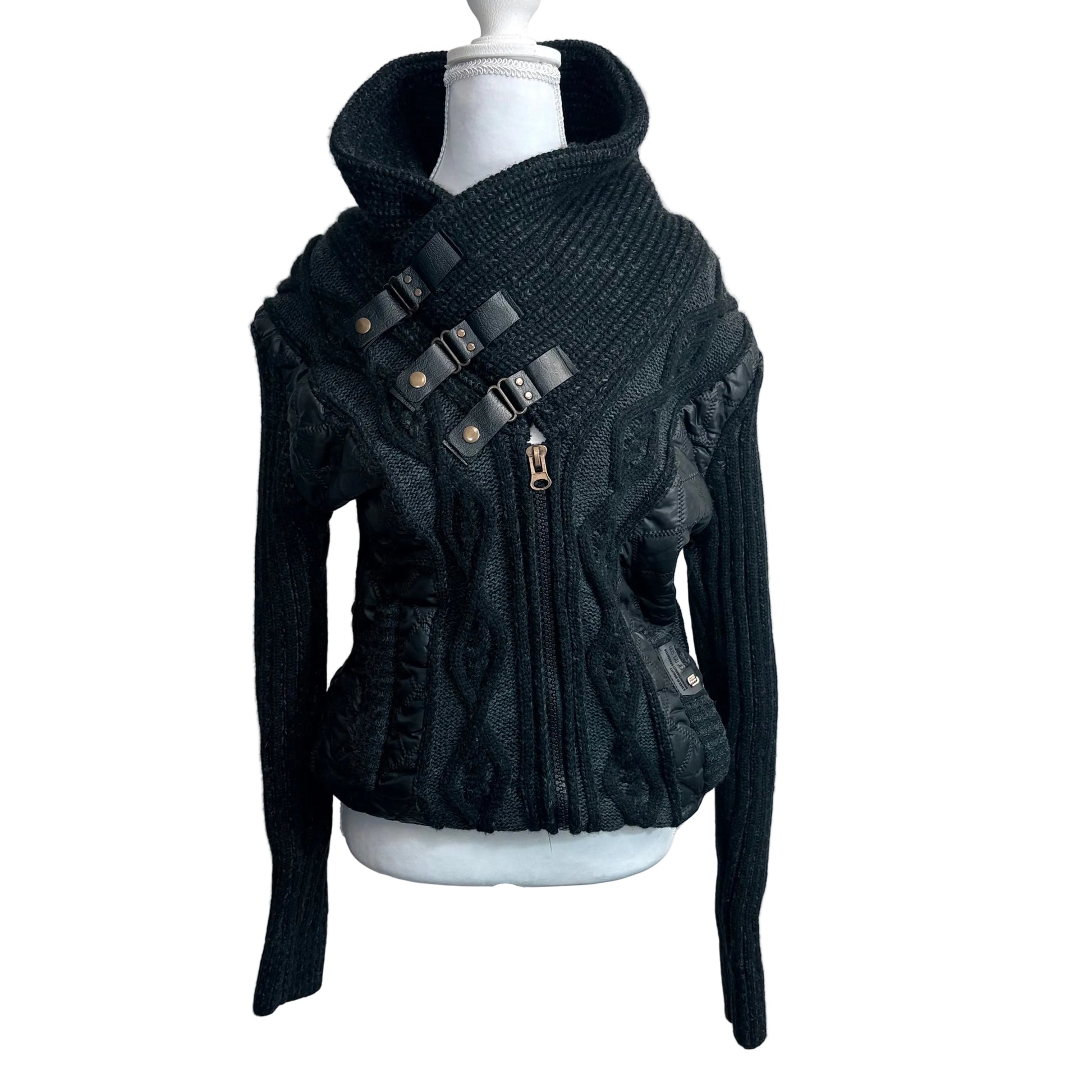 Black knit sweater with leather straps on a mannequin against a white background