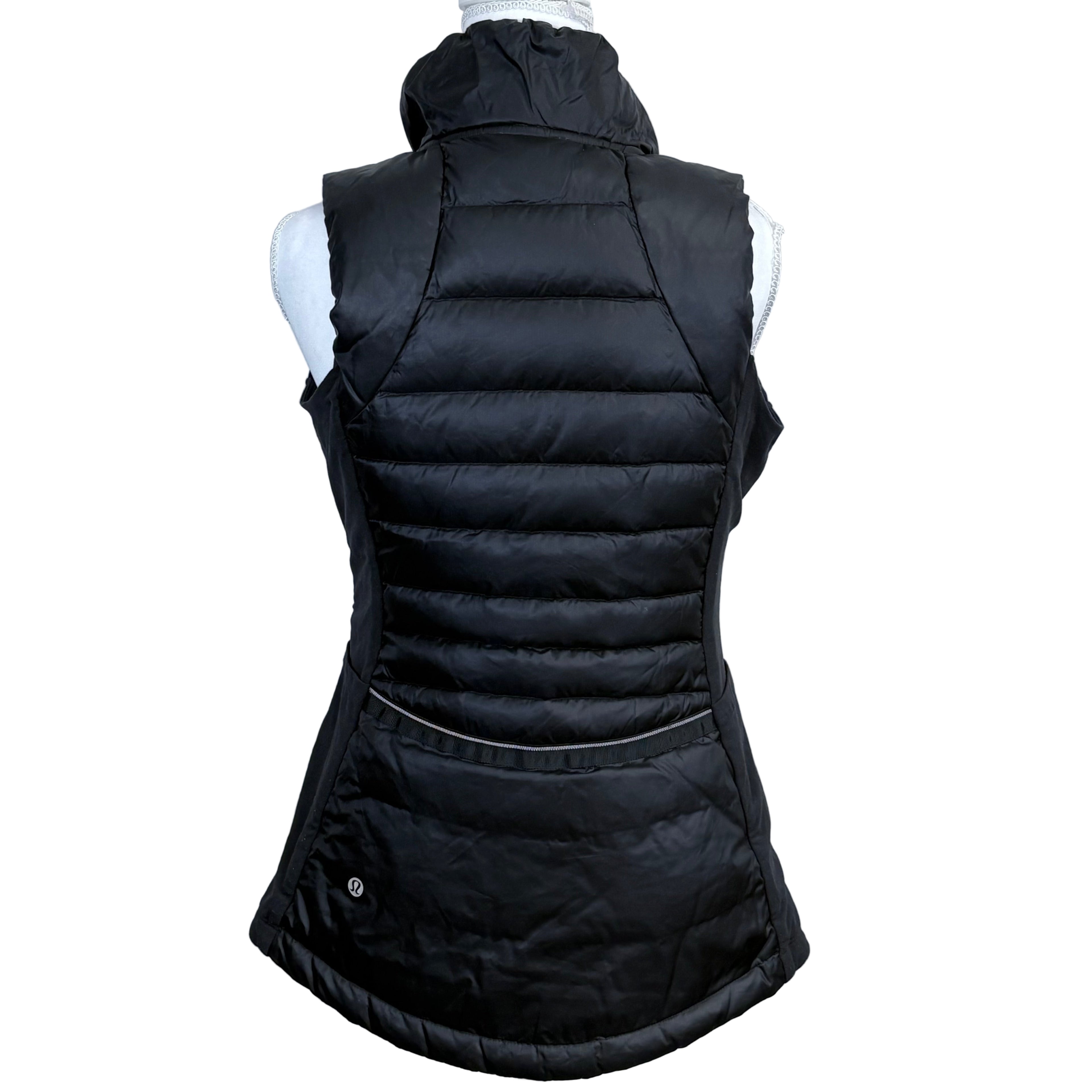 Black puffer vest on a mannequin against a gray background
