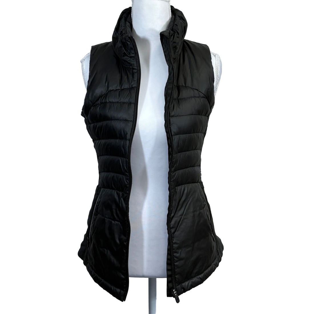 Black puffer vest on a mannequin against a gray background