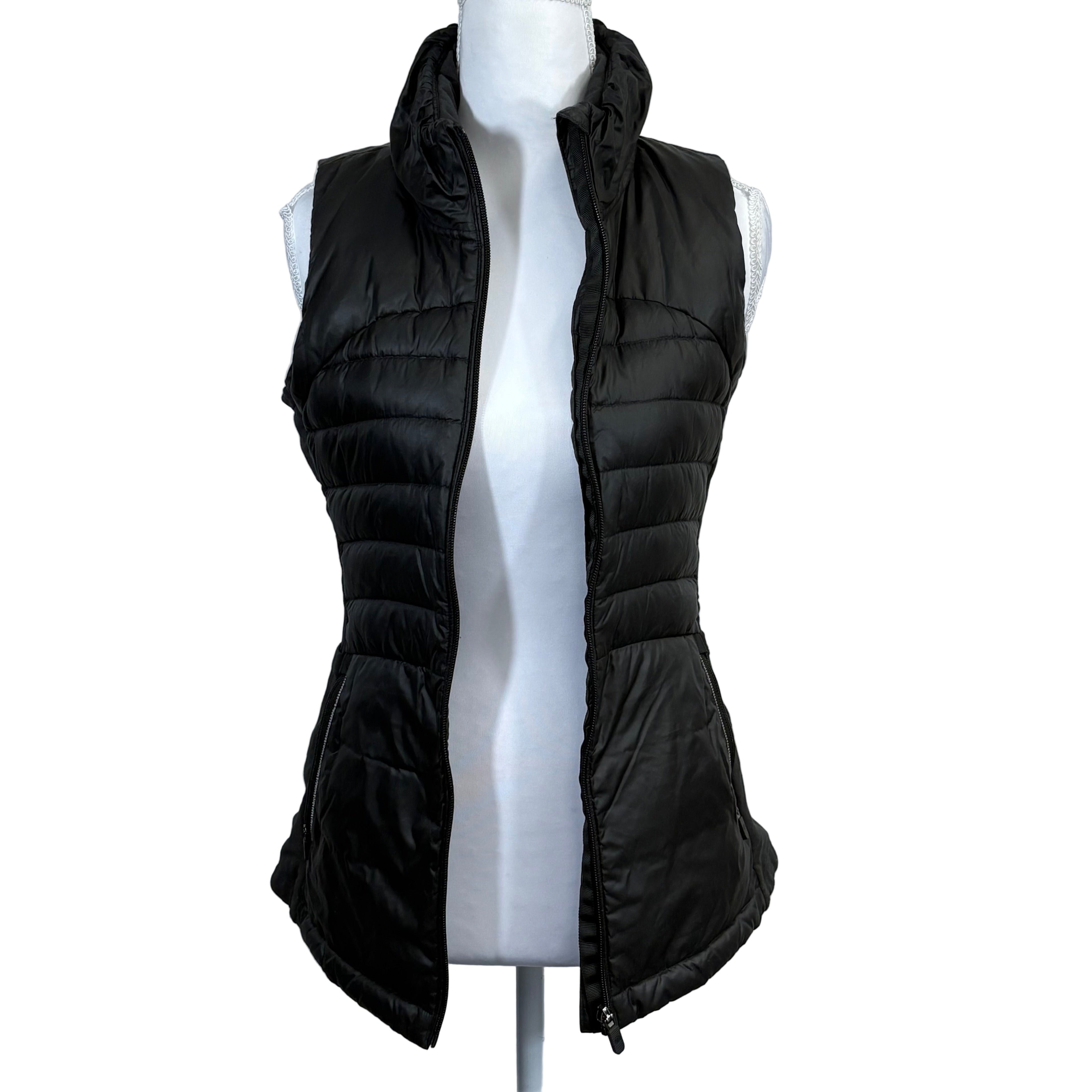 Black puffer vest on a mannequin against a gray background