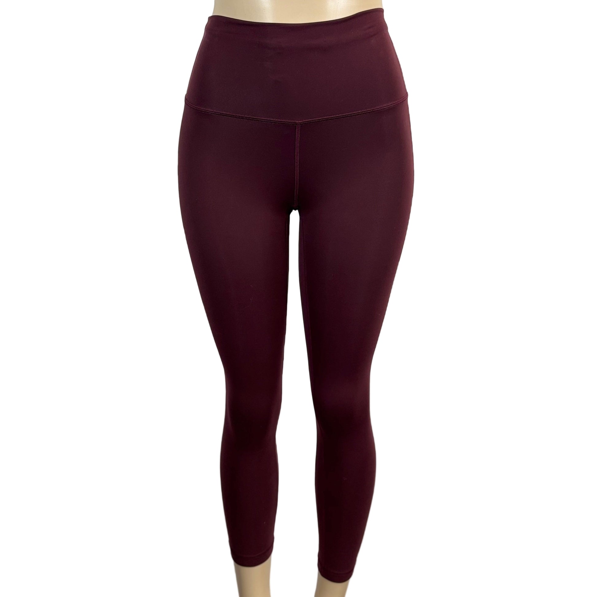 Maroon leggings on a mannequin against a plain background