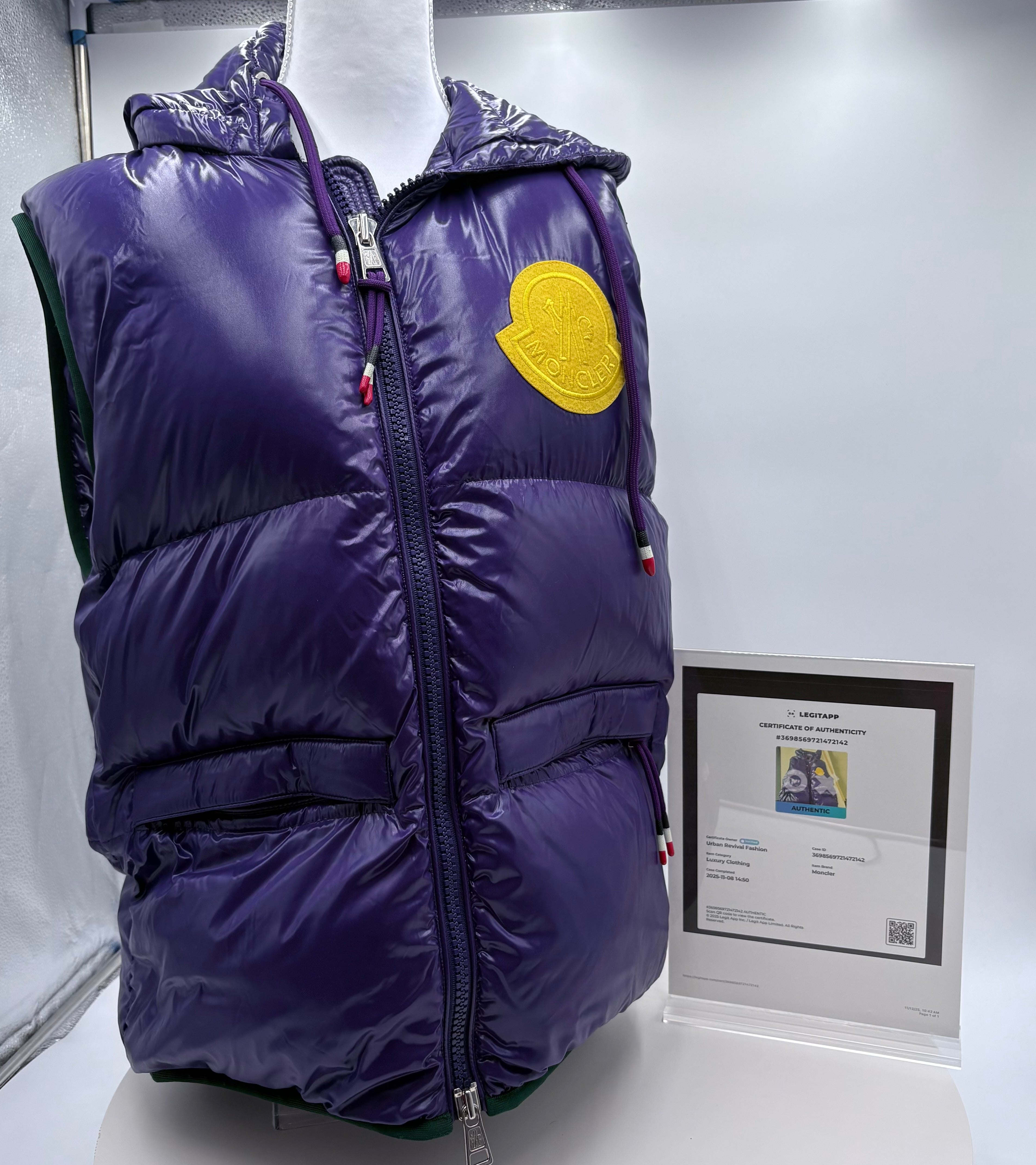 Purple puffer vest with a yellow patch on a mannequin, displayed against a white background.