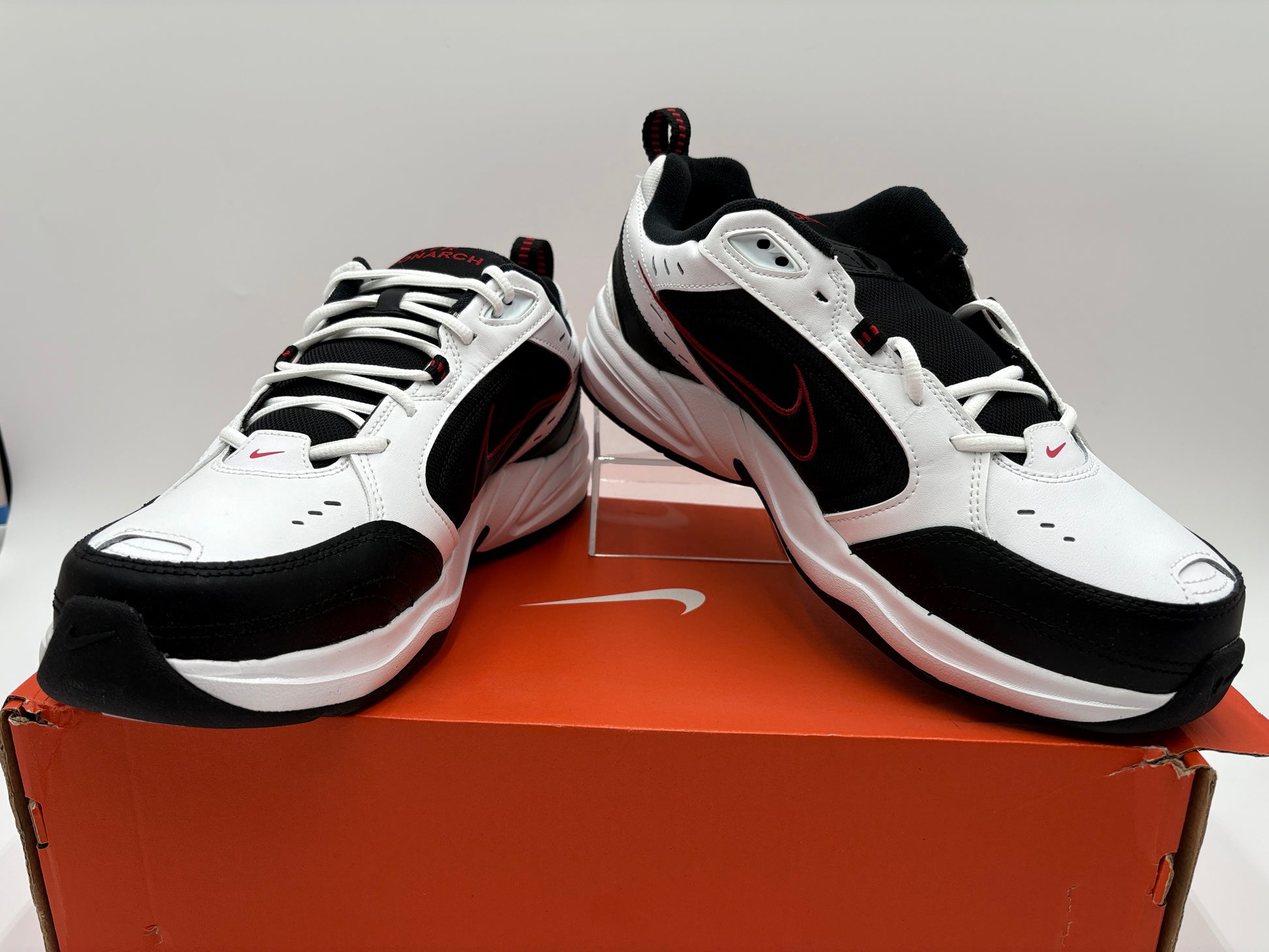 Black and white athletic shoes on a Nike box with a gray background