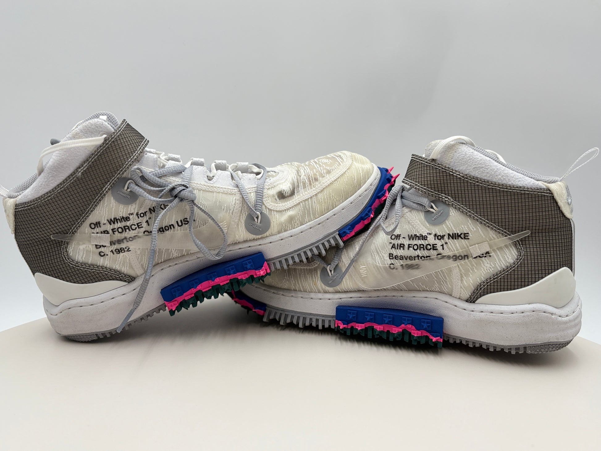 White sneakers with text and colorful soles on a light gray background