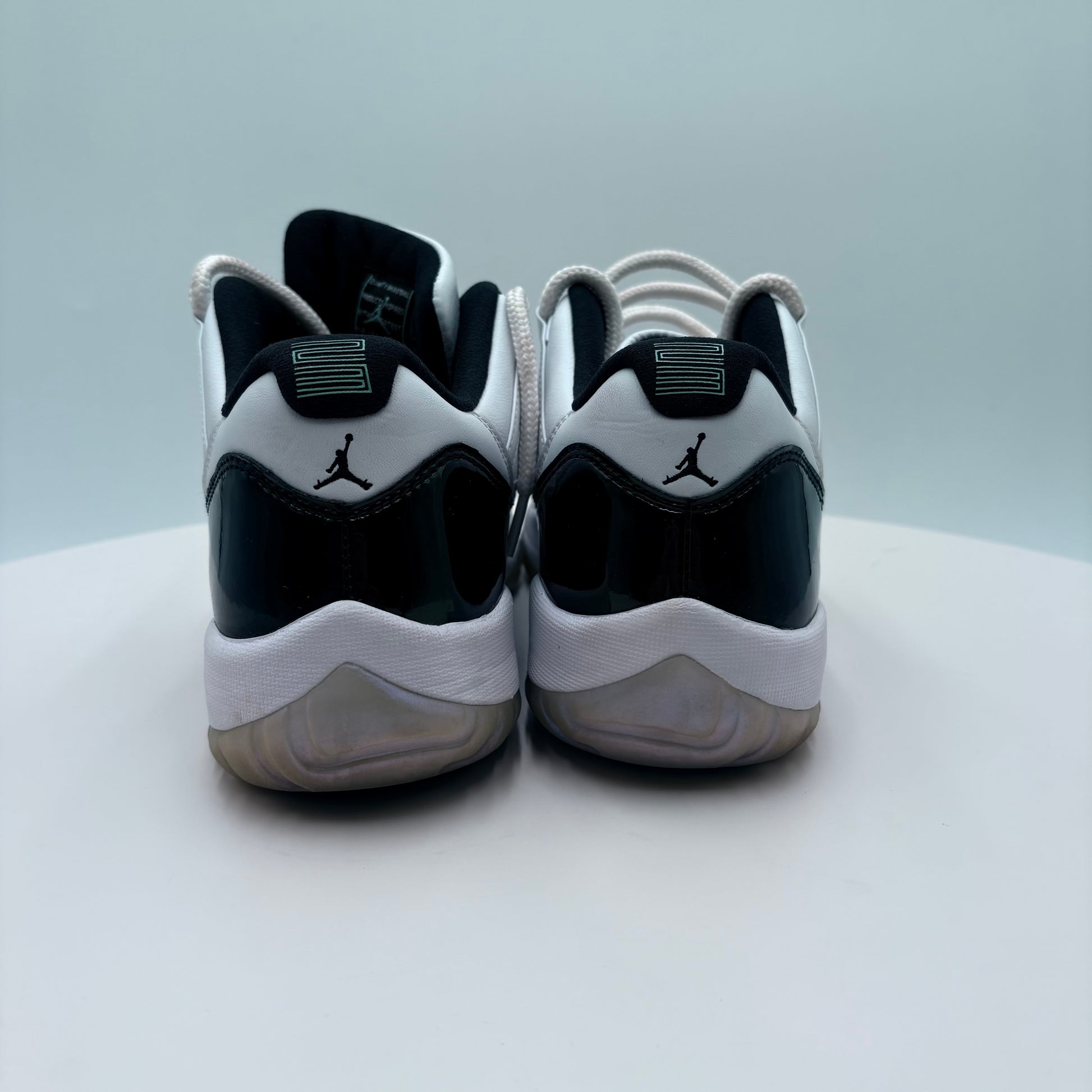 Pair of black and white sneakers with a logo on a light gray background