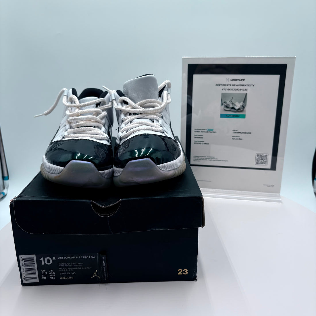 Pair of black and white sneakers on a box with a certificate in the background
