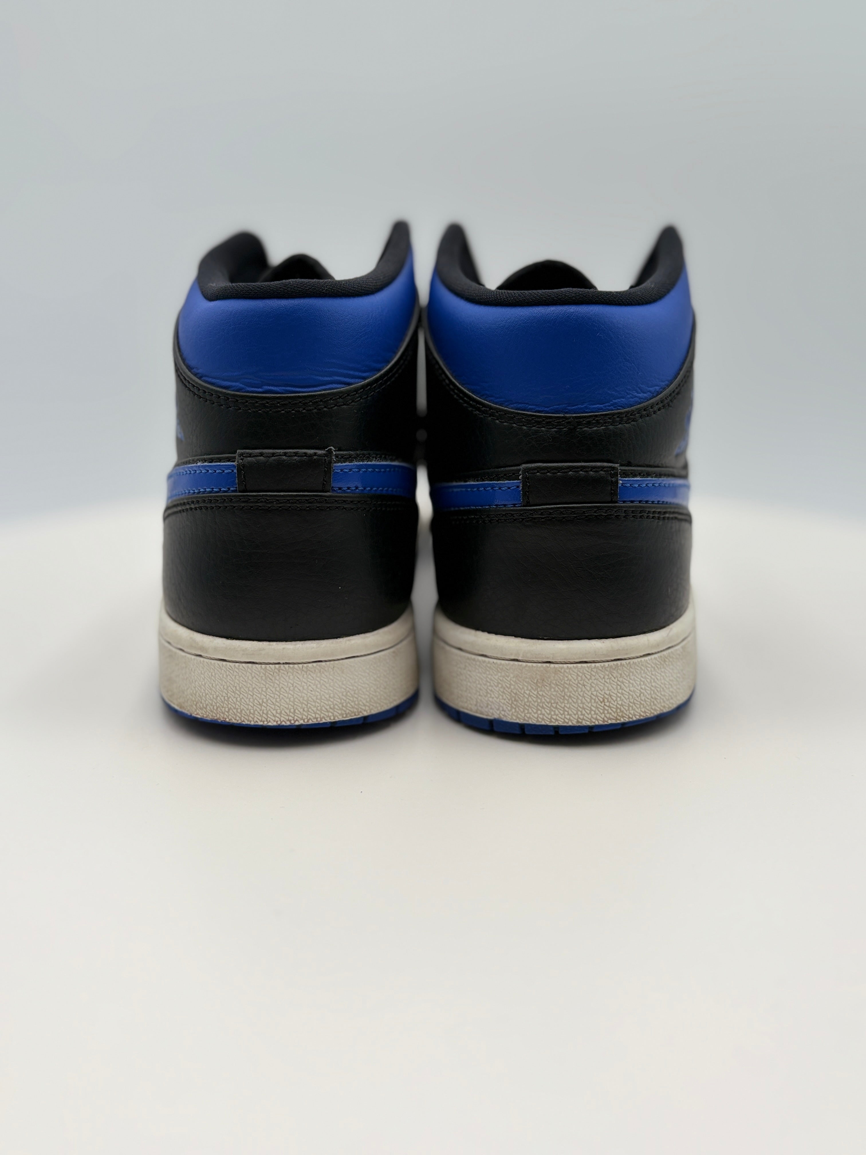 Black and blue sneakers with white soles on a light gray background