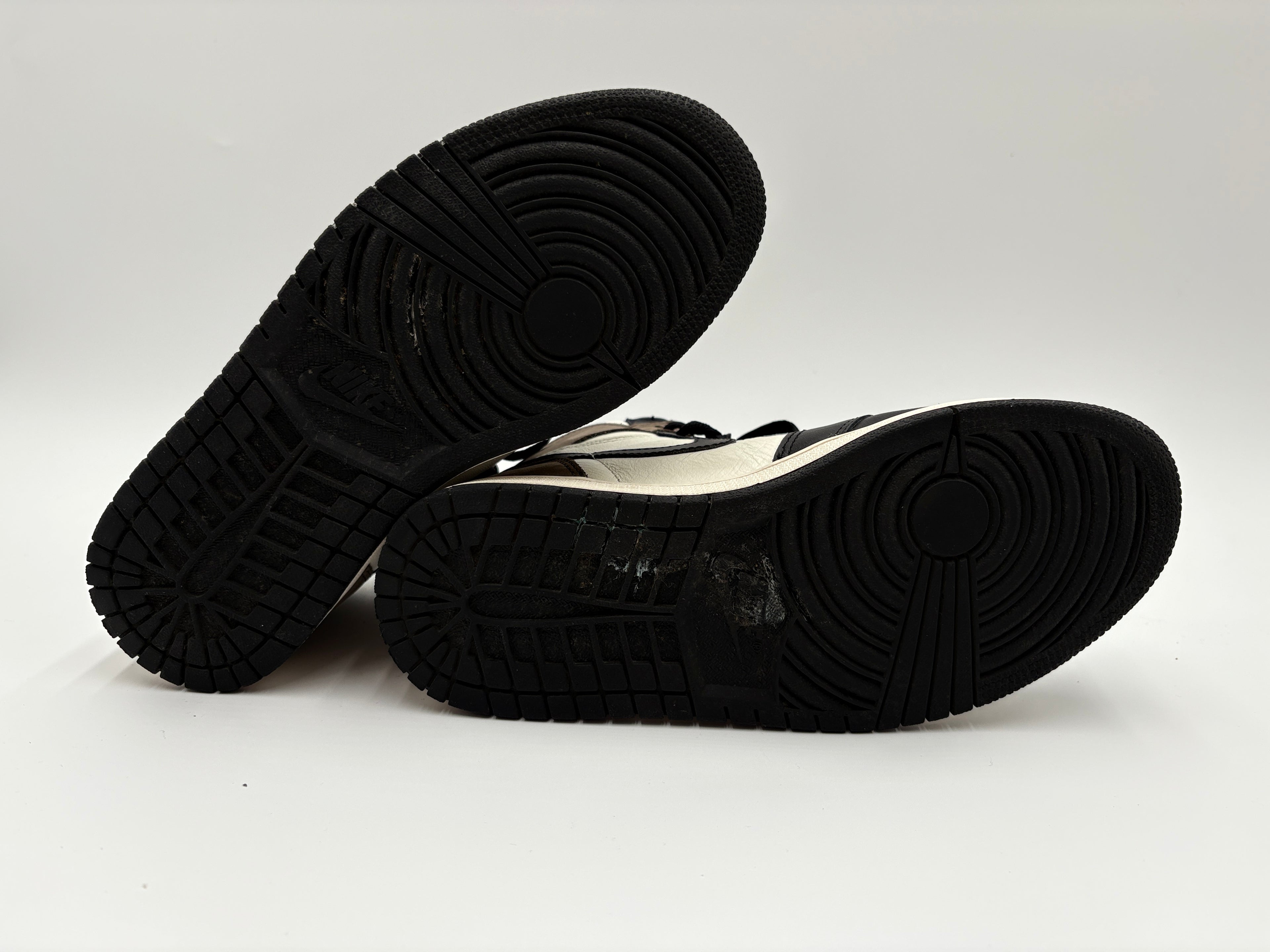 Black soles of  Nike Air Jordan 1 Retro High OG Dark Mocha - sneakers on a white background