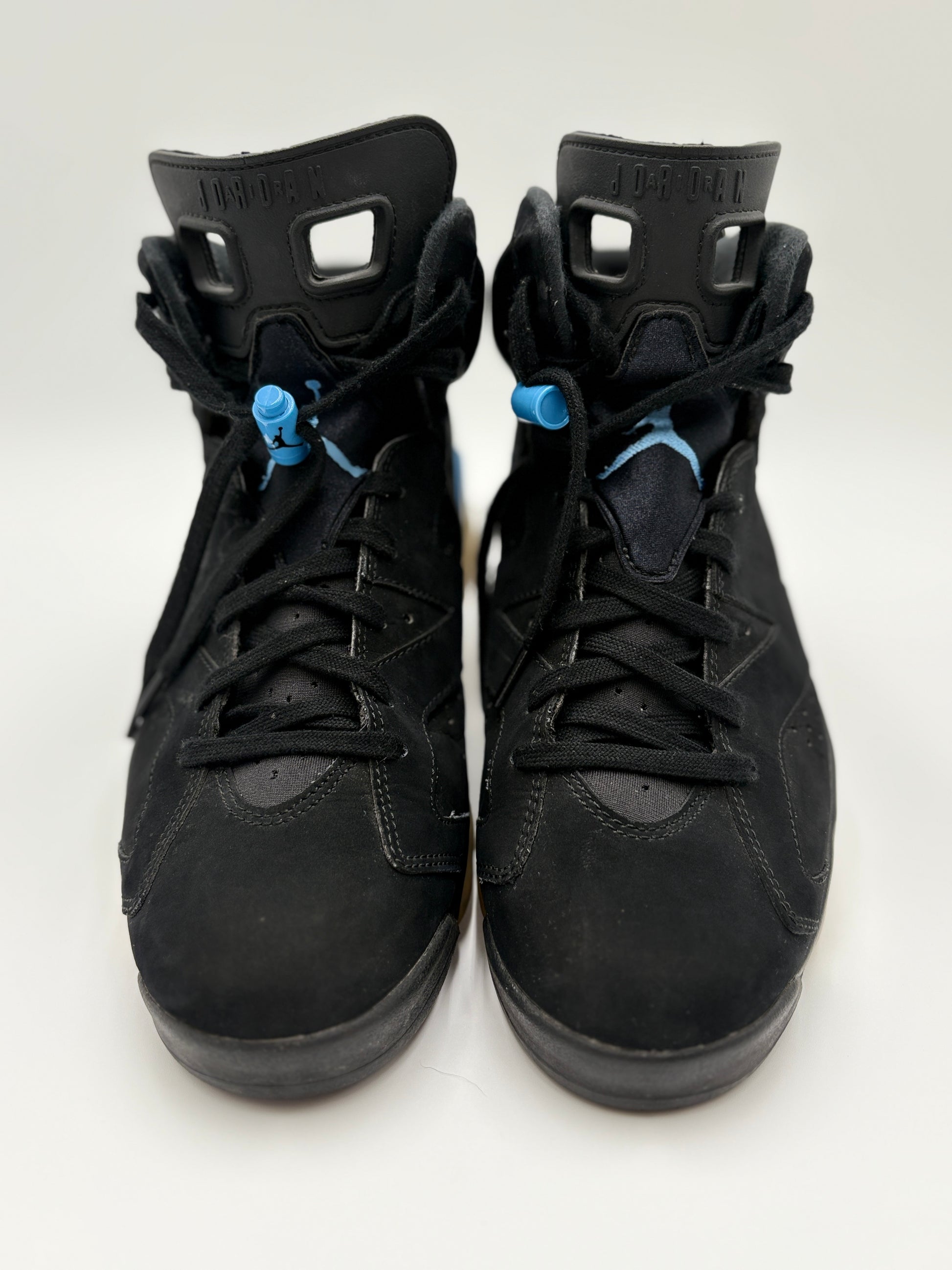 Pair of black high-top sneakers with blue laces on a white background