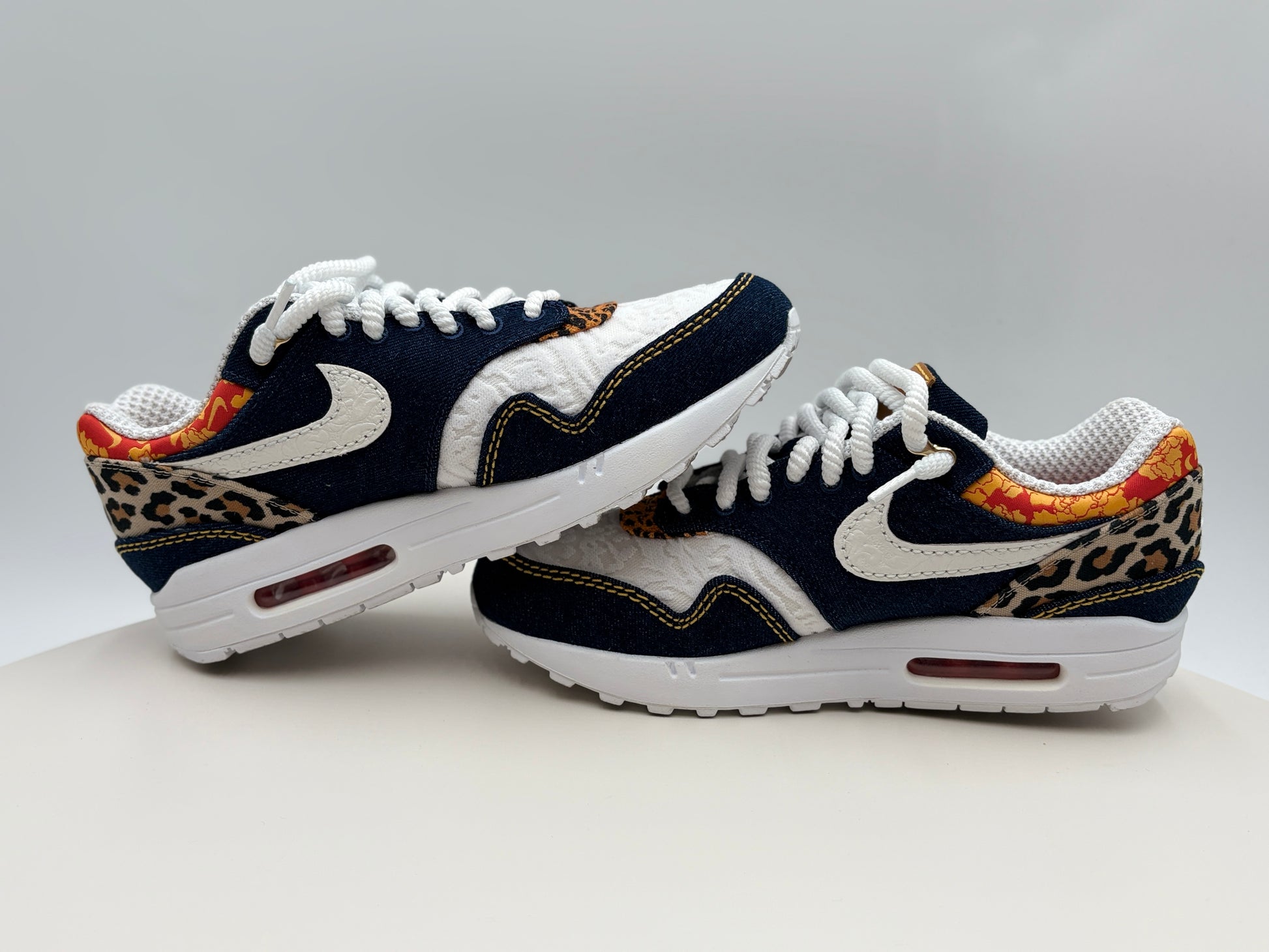 Pair of Nike sneakers with leopard print accents on a light gray background