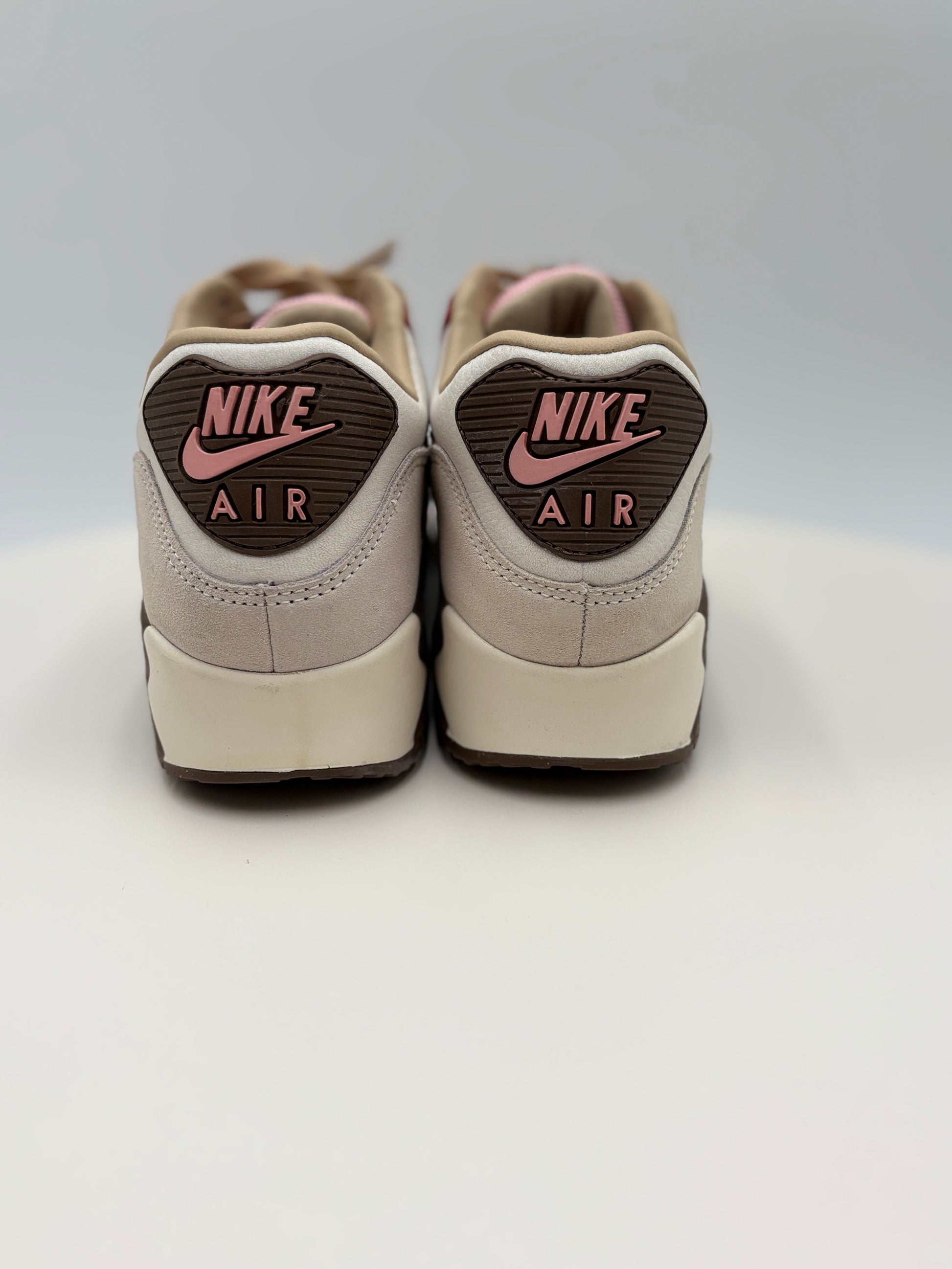 Pair of beige Nike Air Max 90 DQM ‚ÄúBacon‚Äù (CU1816-100)  sneakers with pink swoosh logo on a light gray background