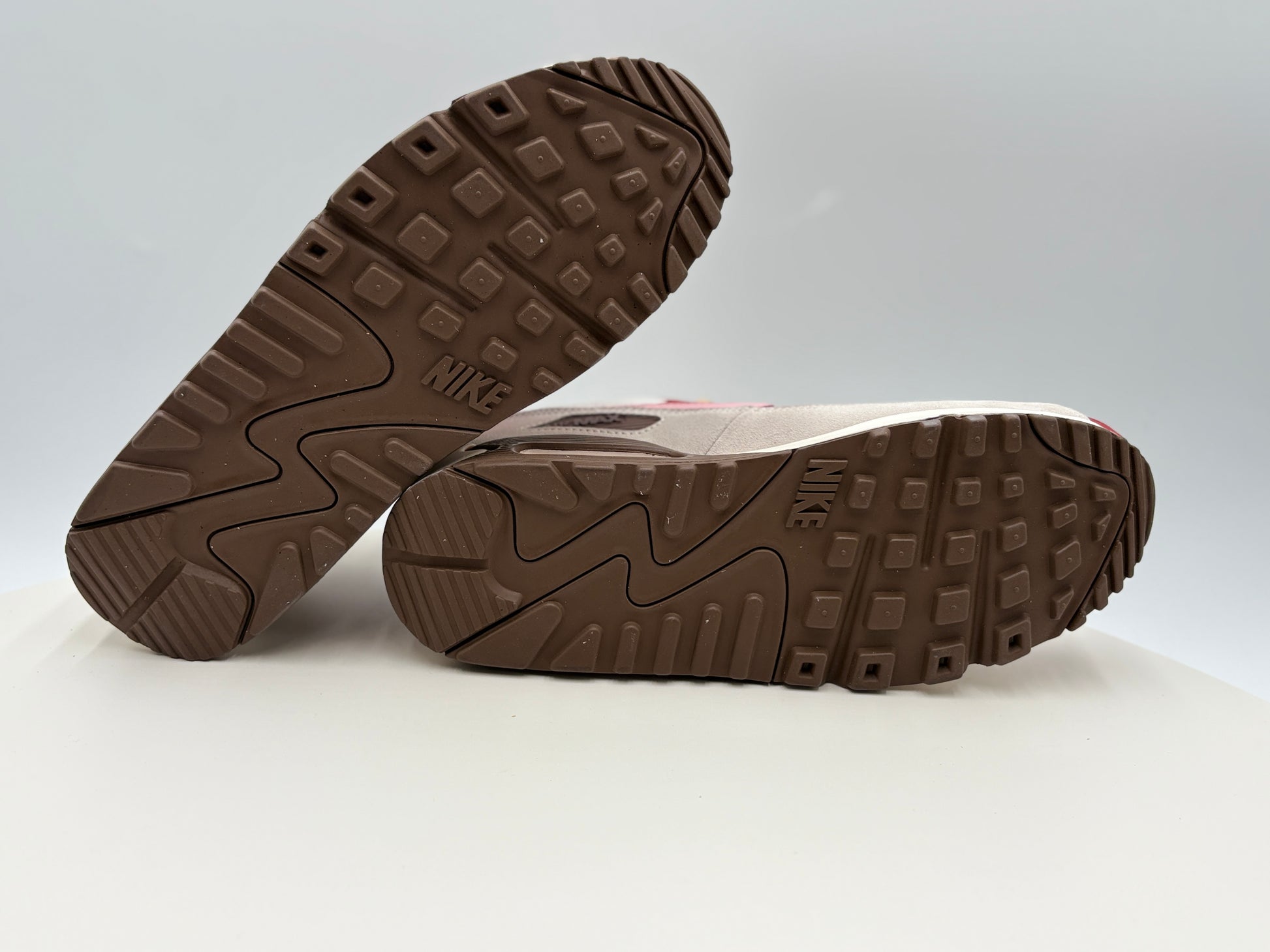 Brown Nike sneakers with sole pattern on a light gray background
