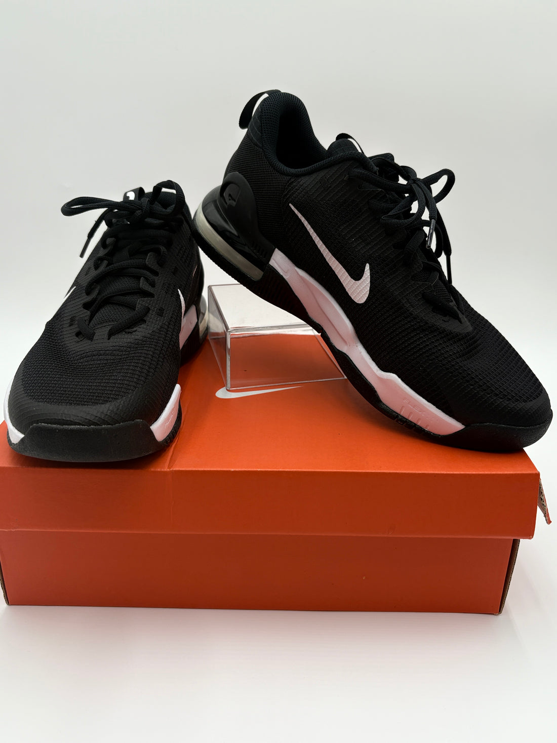 Black Nike sneakers on a brown shoe box with a white background
