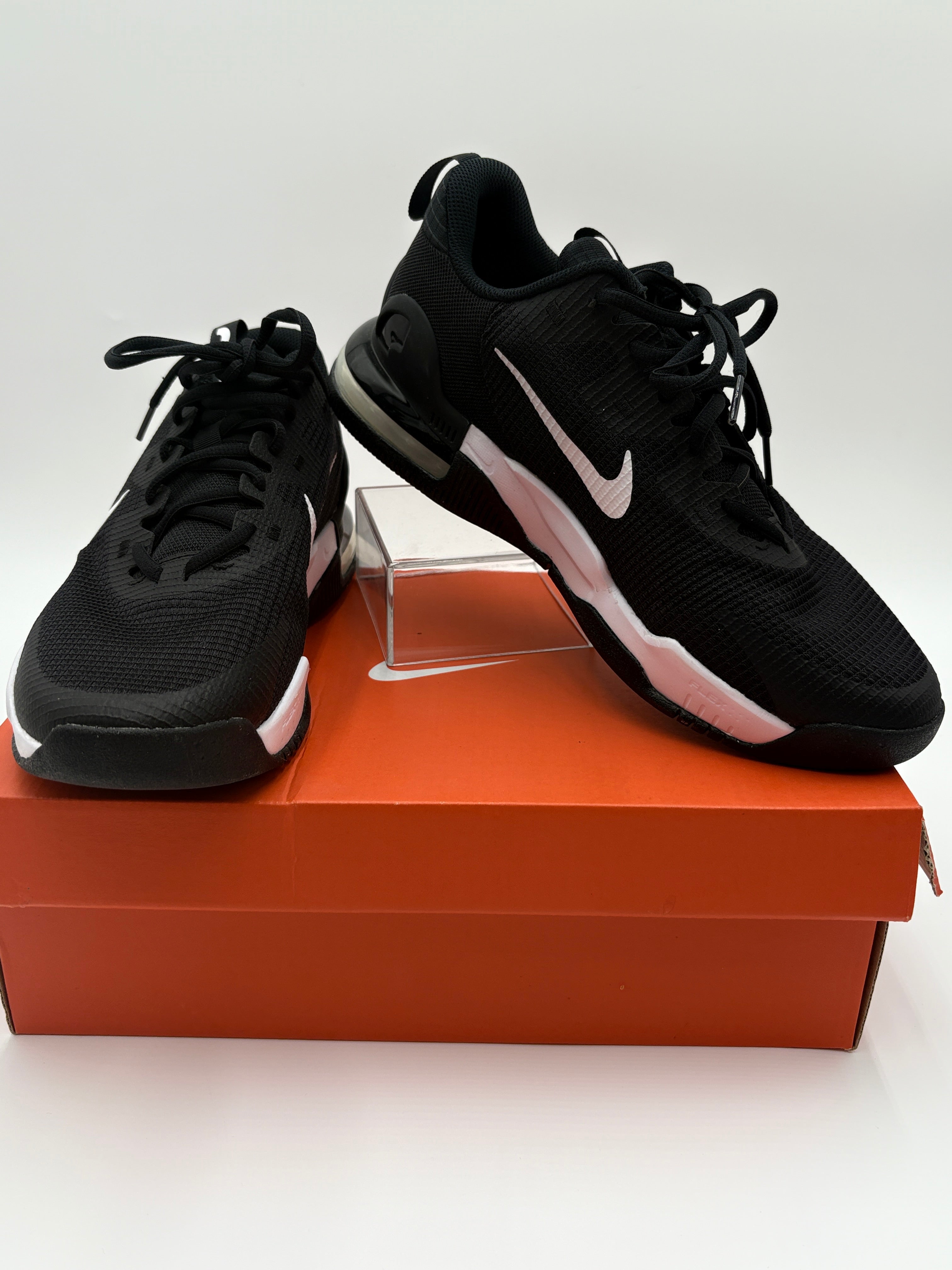 Black Nike sneakers on a brown shoe box with a white background
