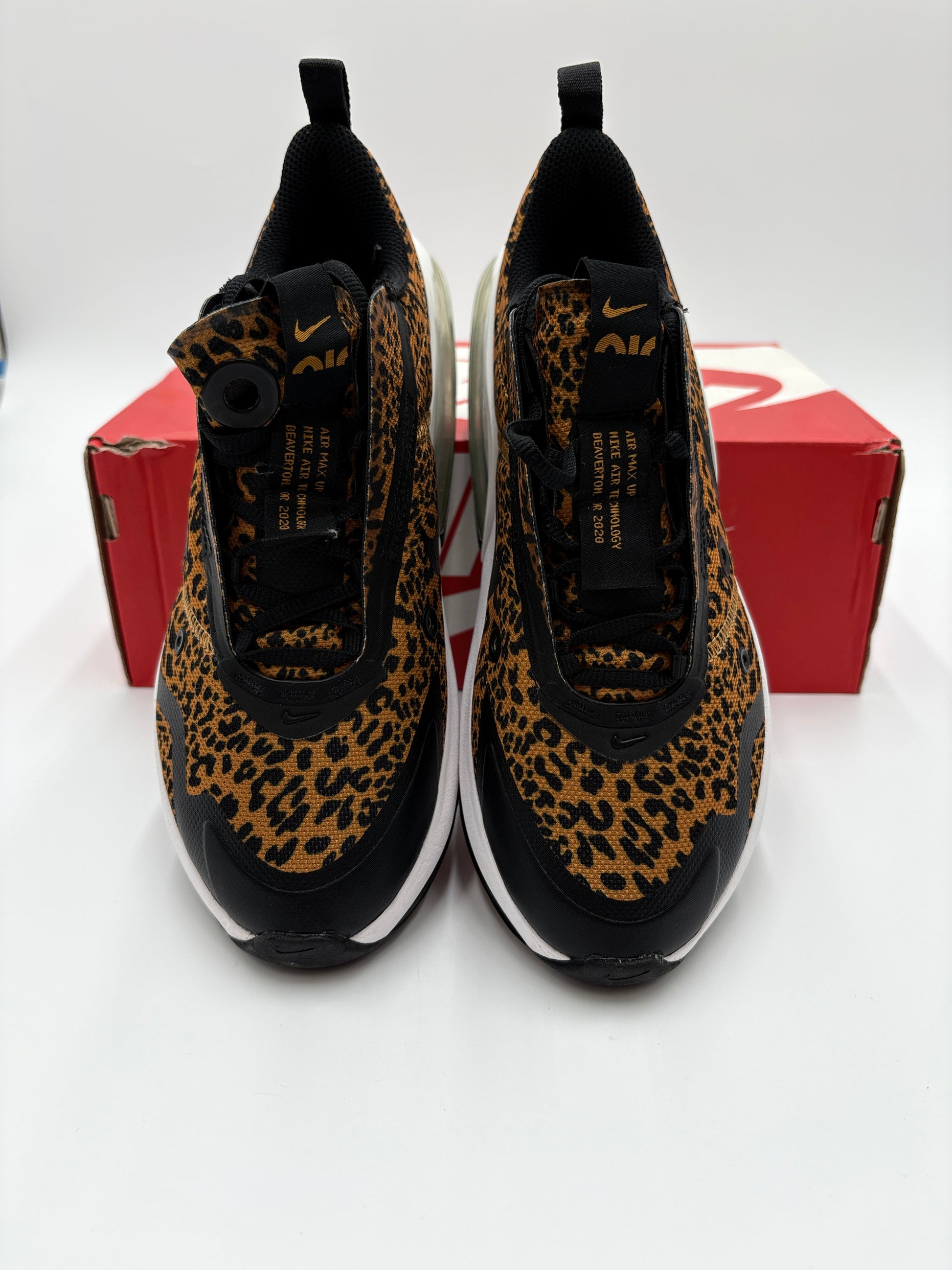 Pair of leopard print sneakers on a white background with a red box.