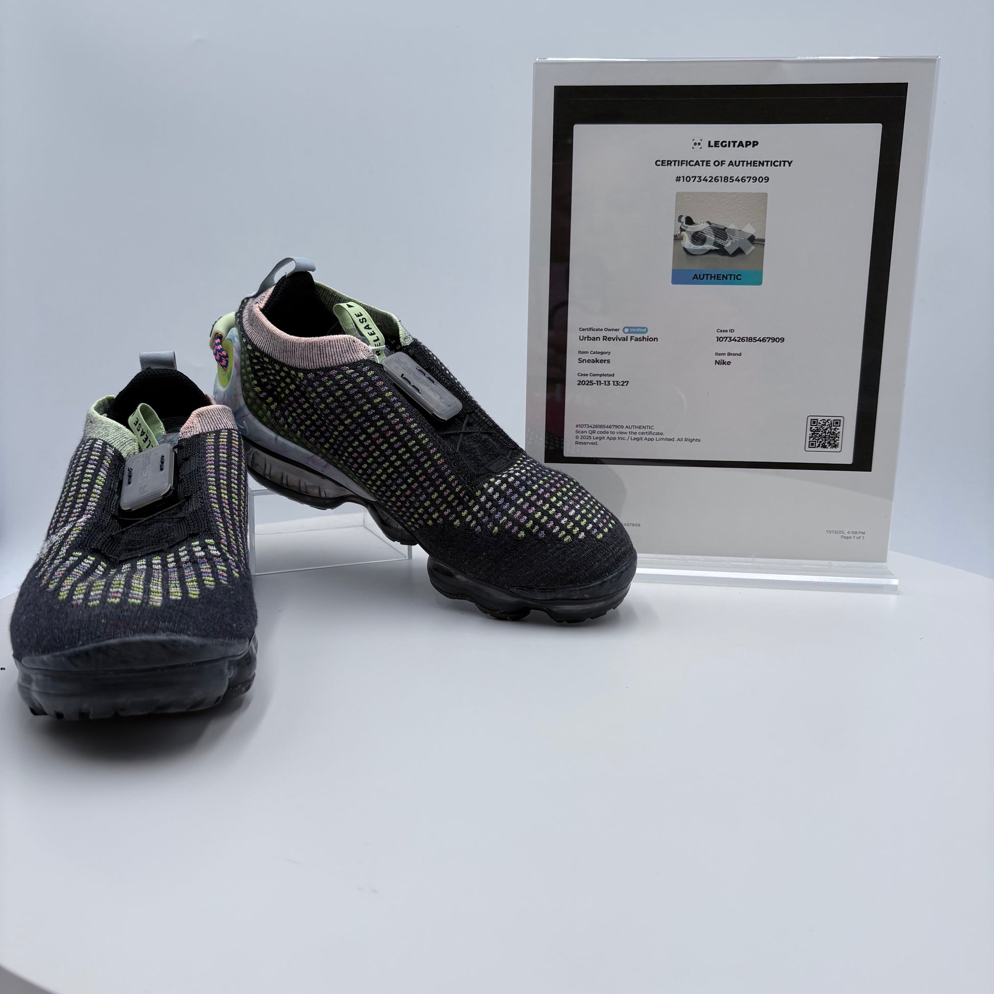 Black athletic shoes with a certificate of authenticity on a white background