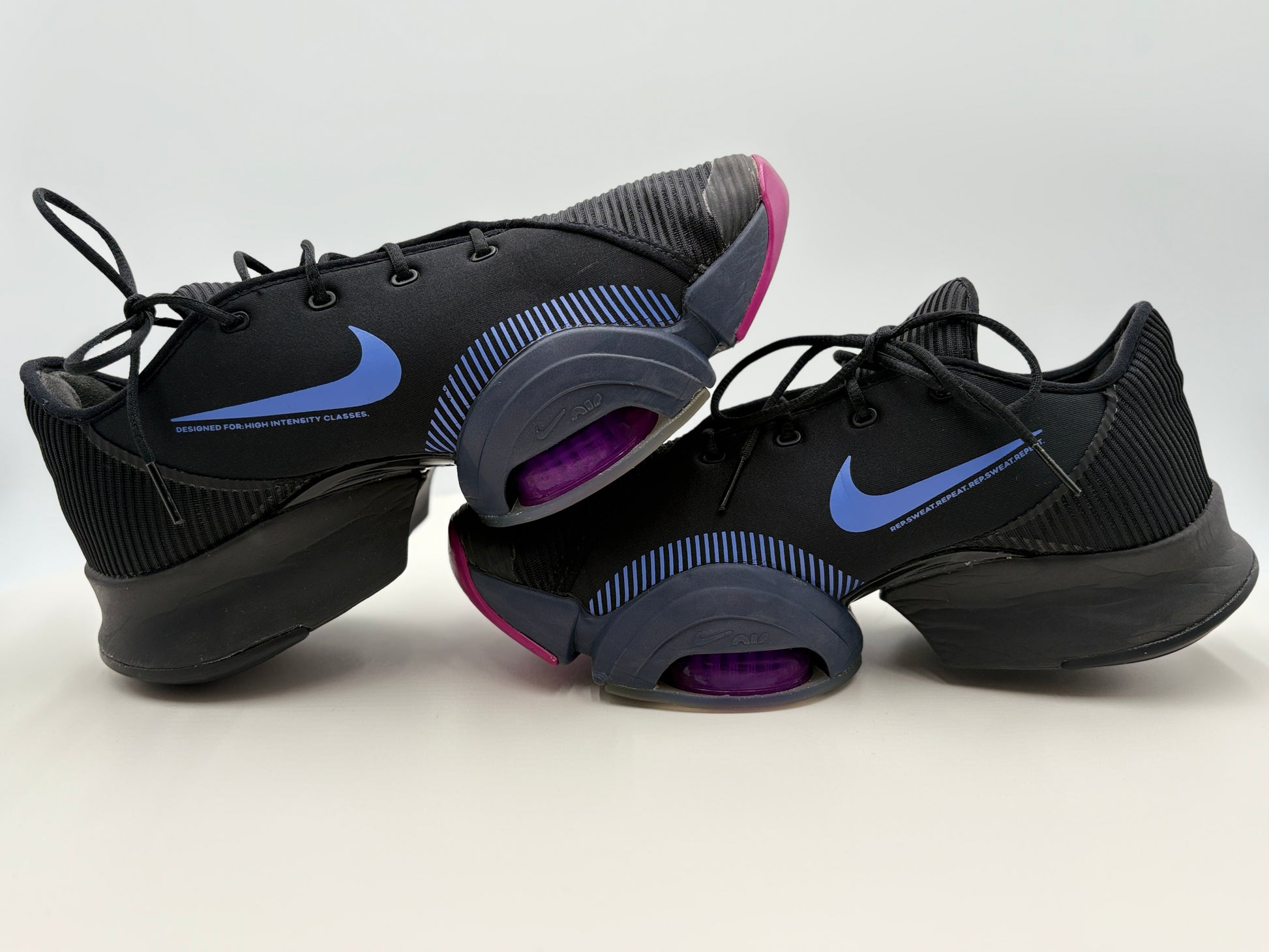 Black athletic shoes with purple and blue accents on a white background