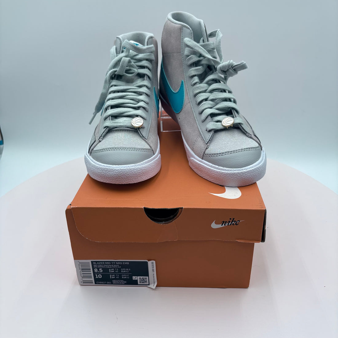 Pair of gray high-top sneakers with blue accents on a light gray background
