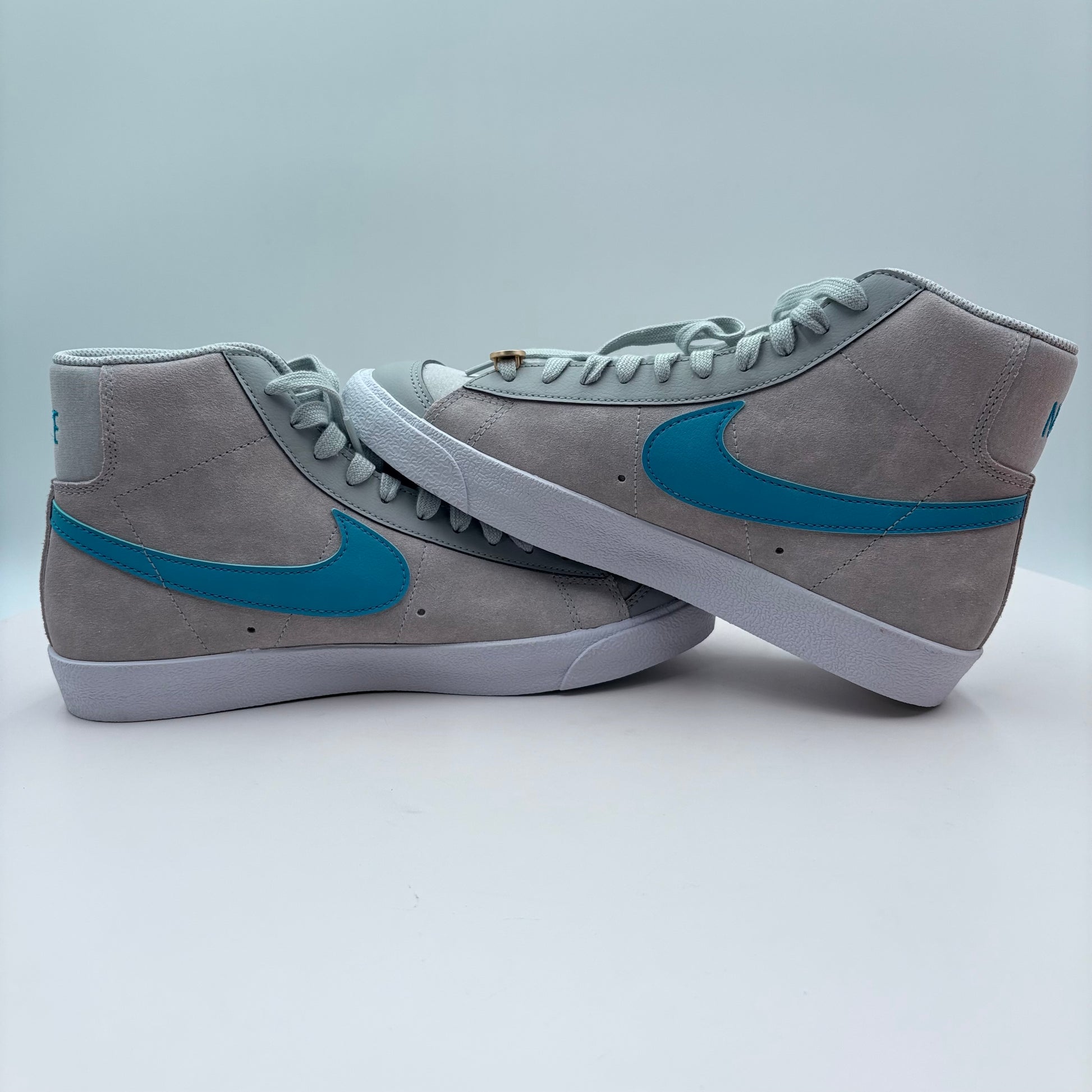 Gray sneakers with blue swoosh logo on a white background