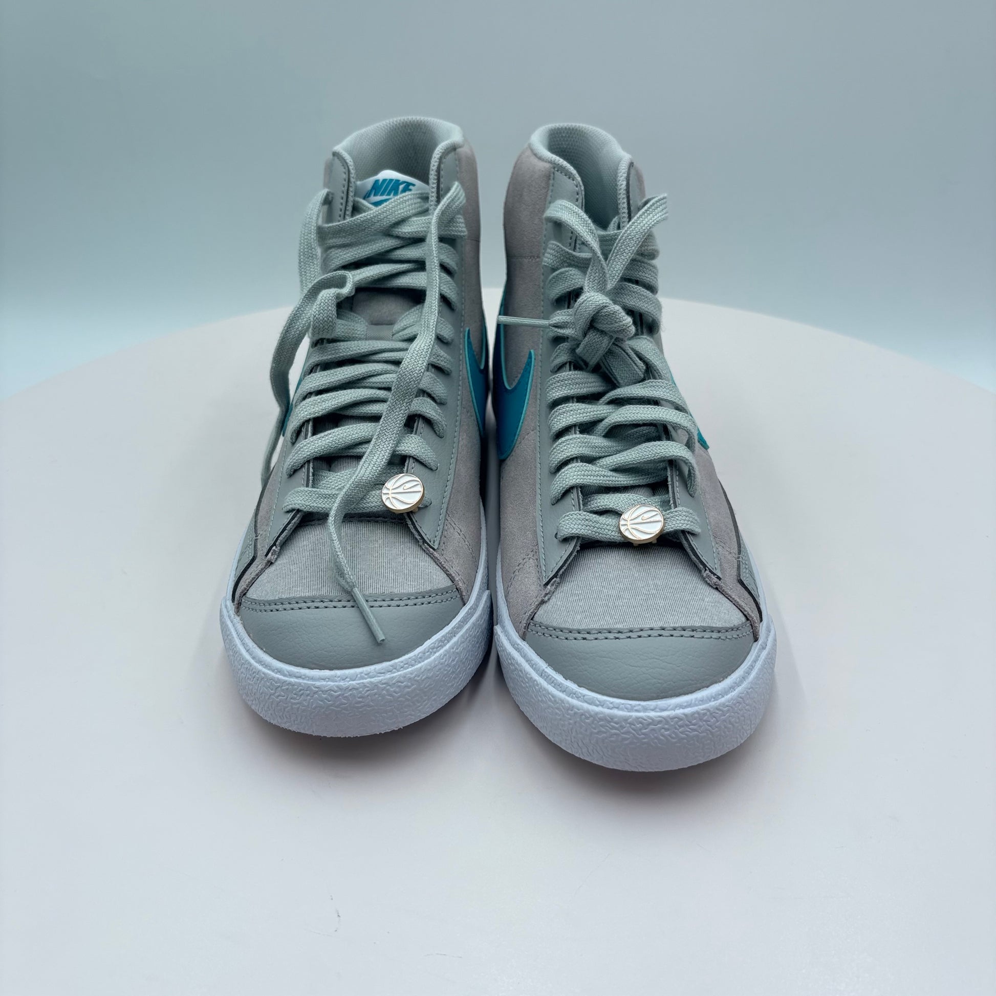 Pair of gray high-top sneakers with blue accents on a light gray background