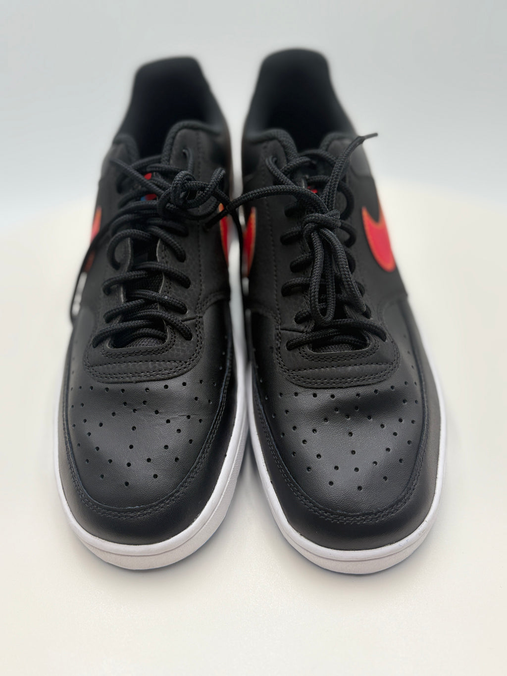 Black sneakers with red accents on a white background