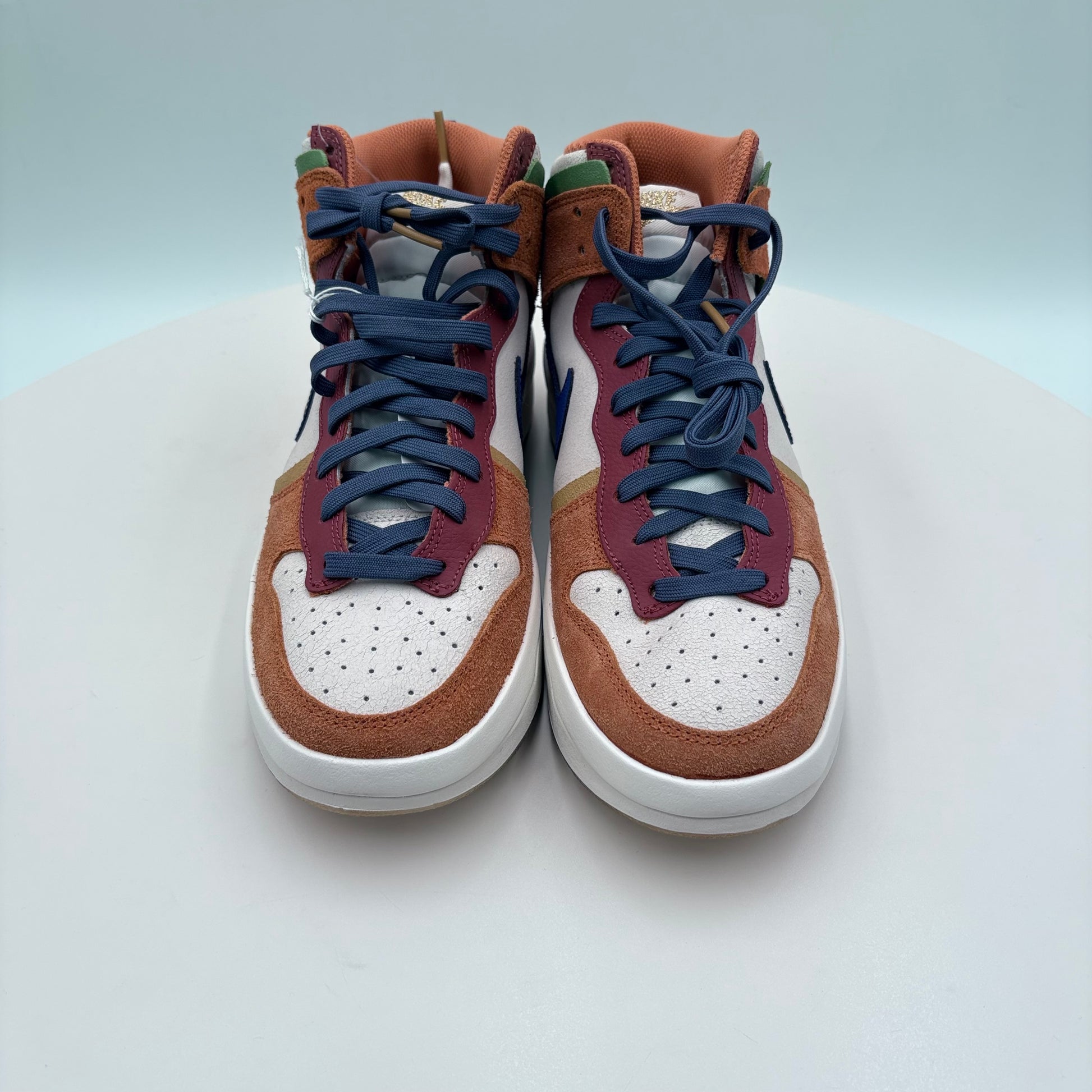 Pair of high-top sneakers with brown, blue, and white color scheme on a light gray background