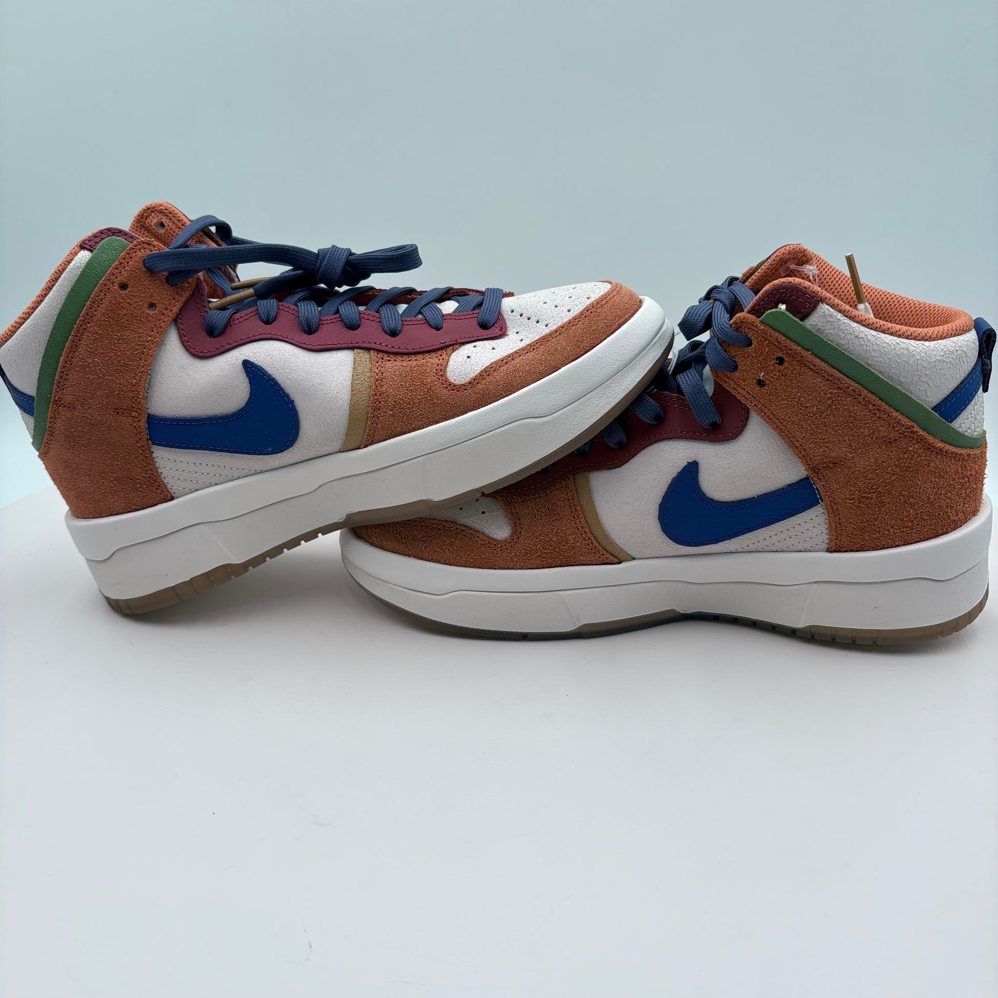 Pair of high-top sneakers with a blue Nike logo on a light gray background
