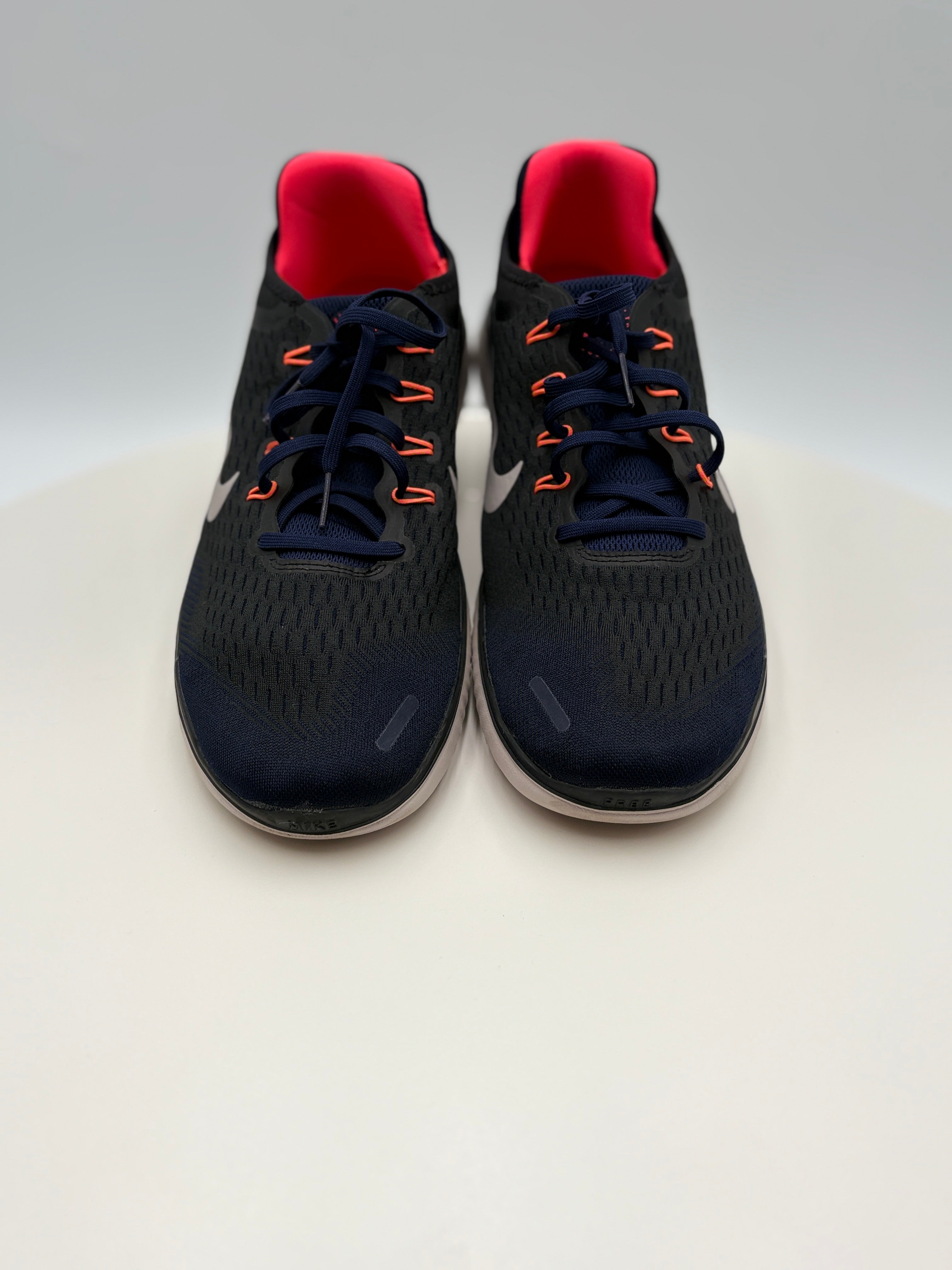 Black running shoes with red accents on a white background
