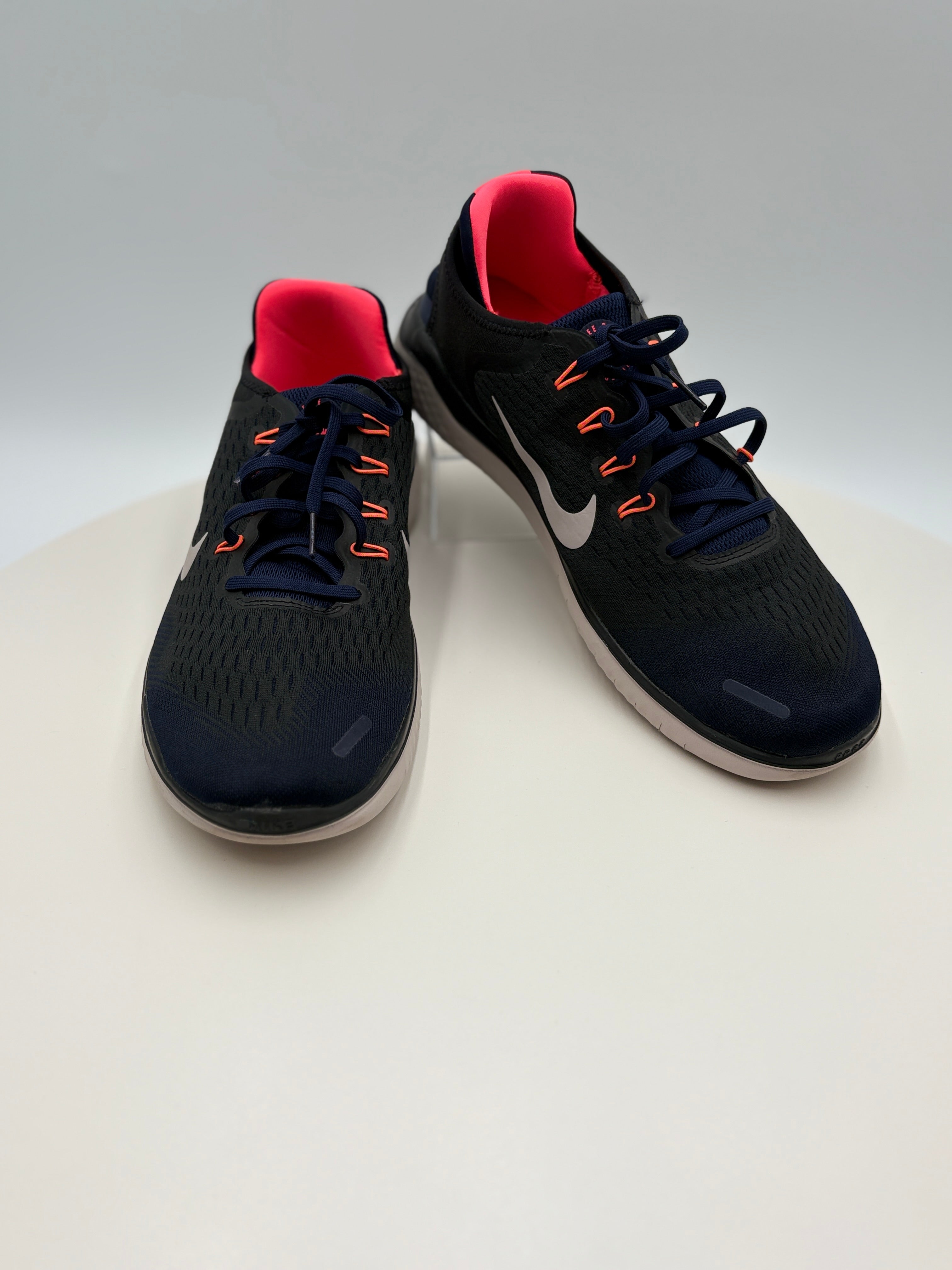 Black running shoes with red lining on a white background
