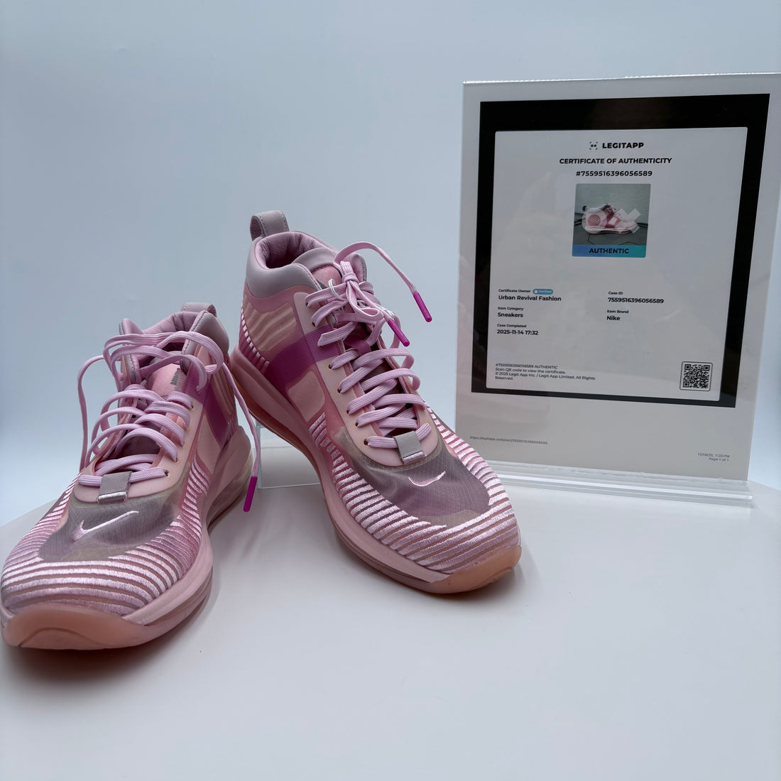 Pink sneakers with a certificate of authenticity on a light gray background