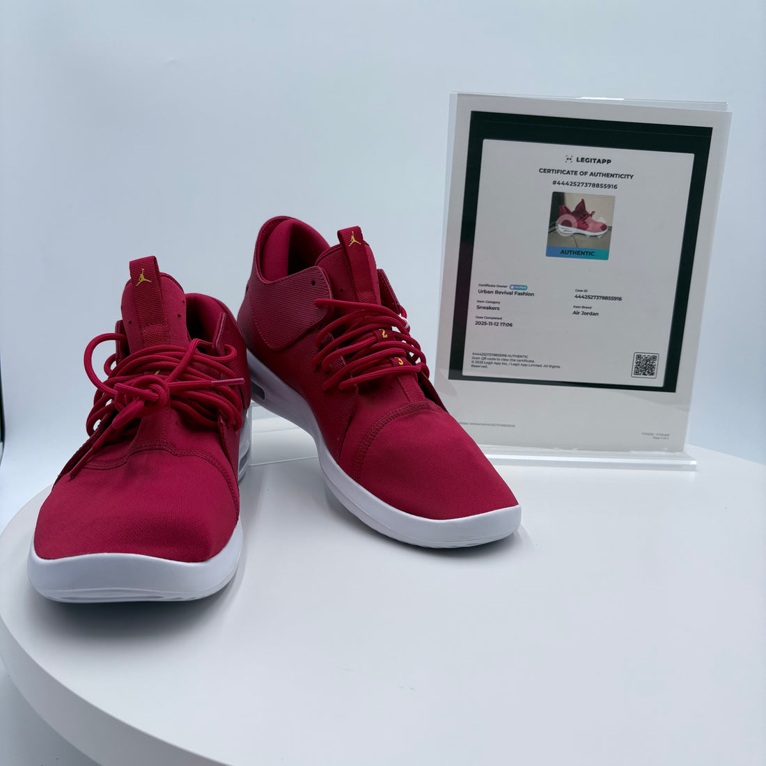 Red sneakers with a certificate of authenticity on a white surface