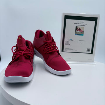 Red sneakers with a certificate of authenticity on a white surface