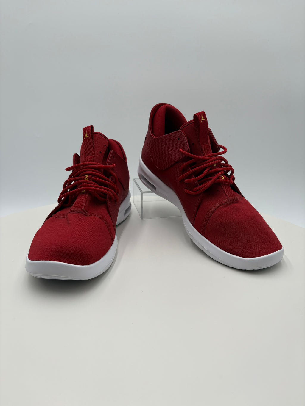 Pair of red high-top sneakers with white soles on a light gray background