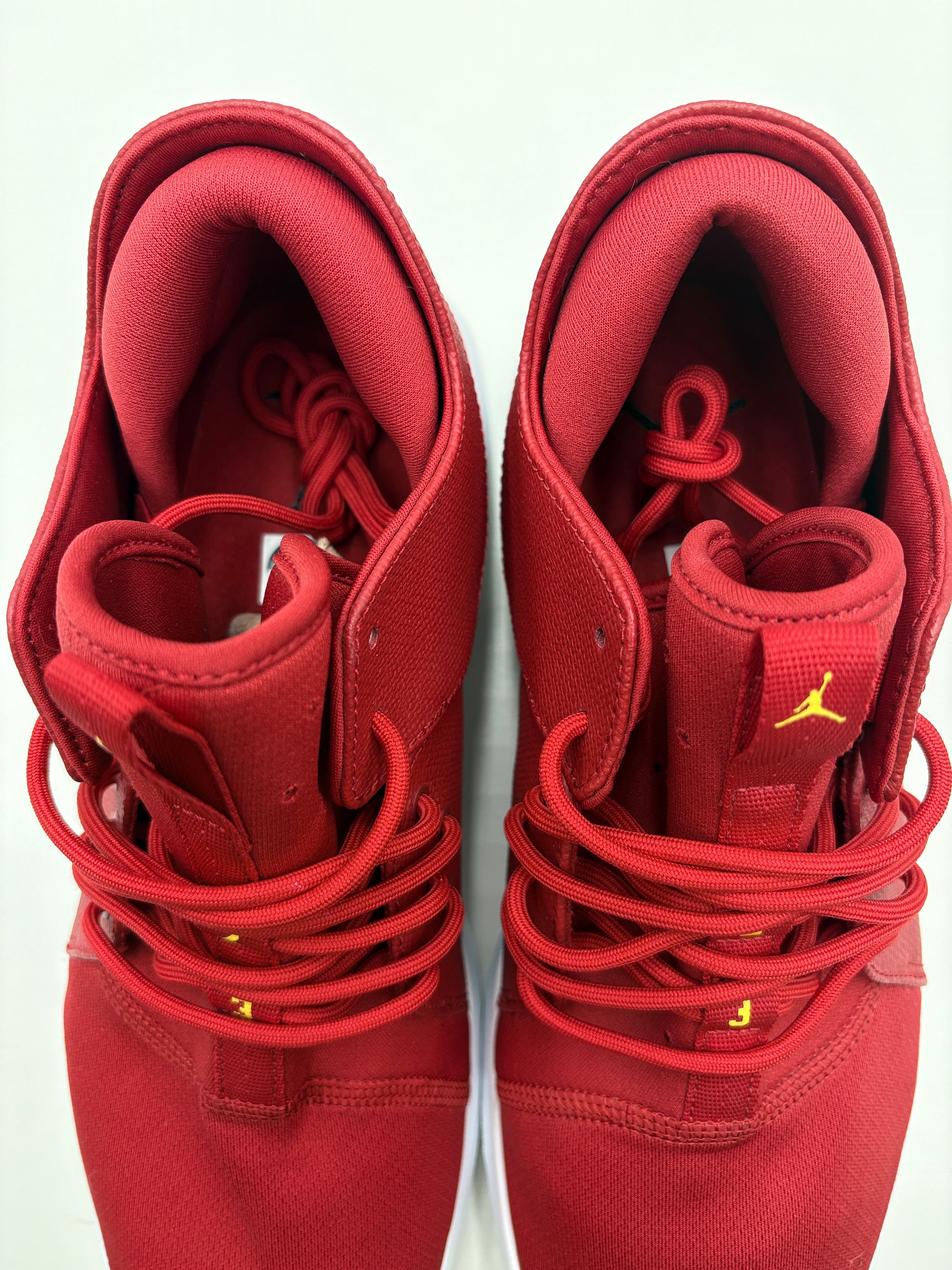 Red high-top sneakers with a brand logo on a white background