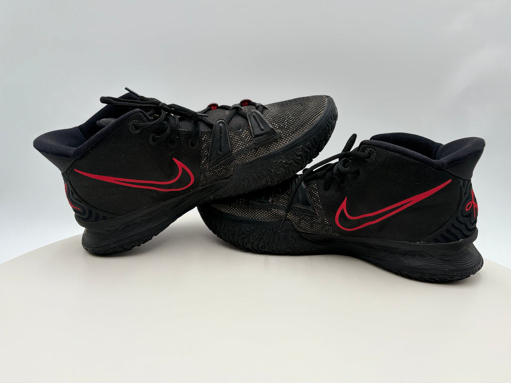 Styled - Black basketball shoes with red swoosh logo on a white background 