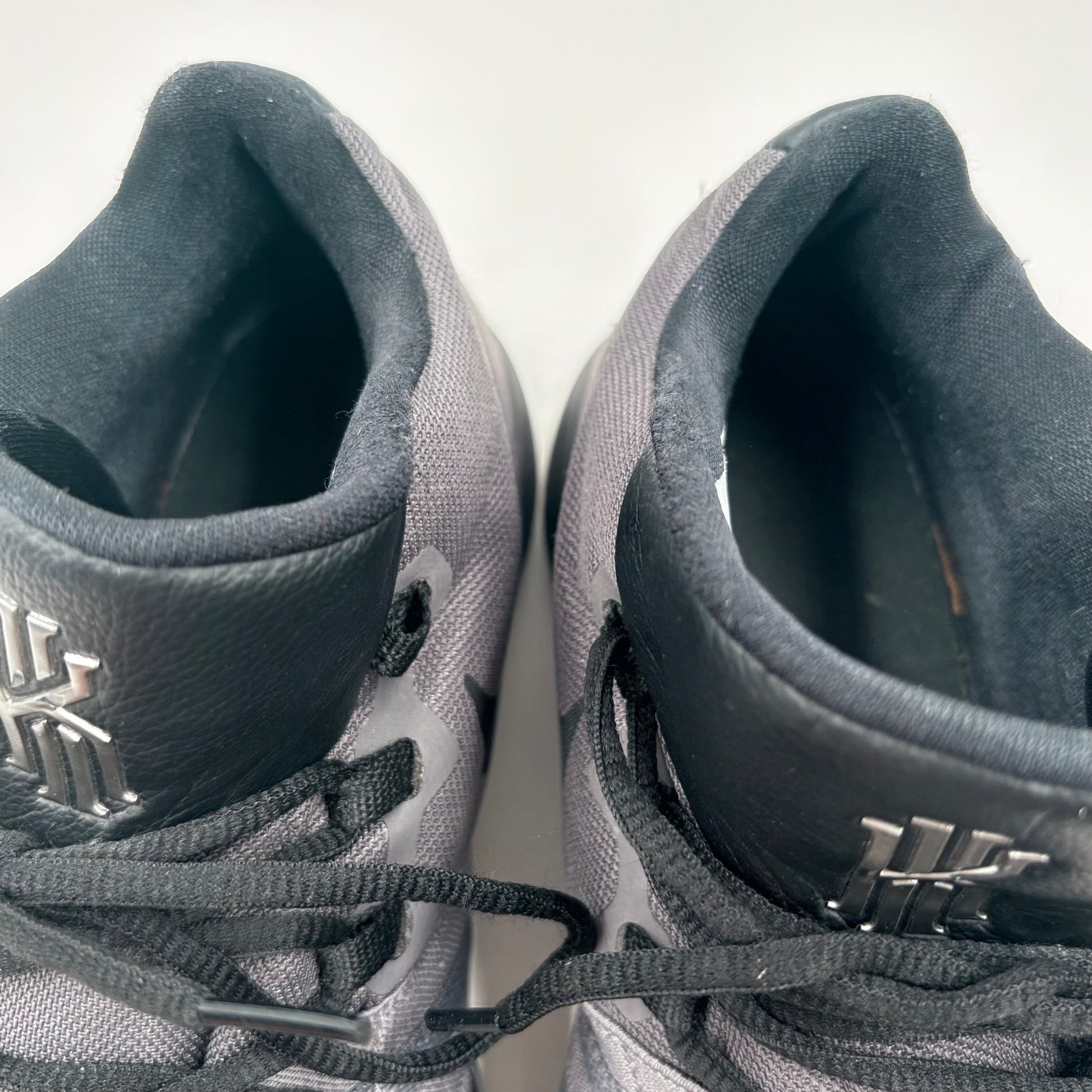 Close-up of a pair of gray sneakers with brand logos on a white background