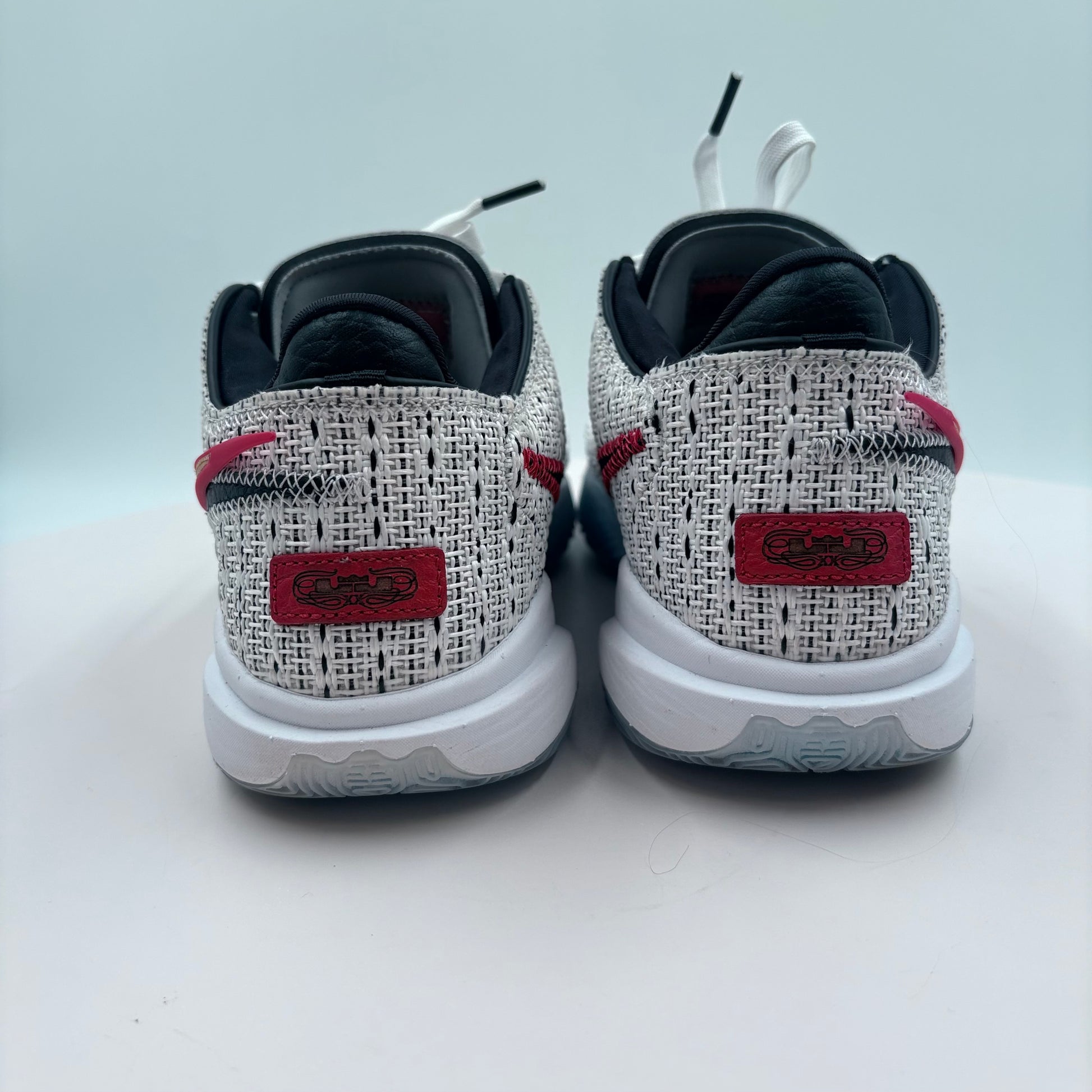 Black and white sneakers with red accents on a light gray background