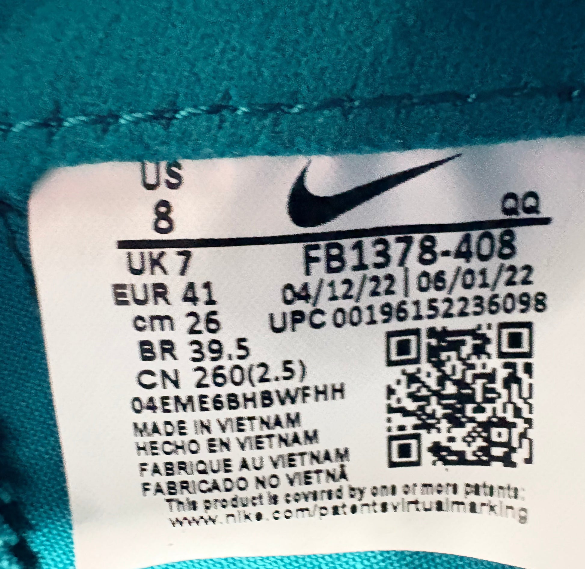 Close-up of a Nike label with product details on a teal background