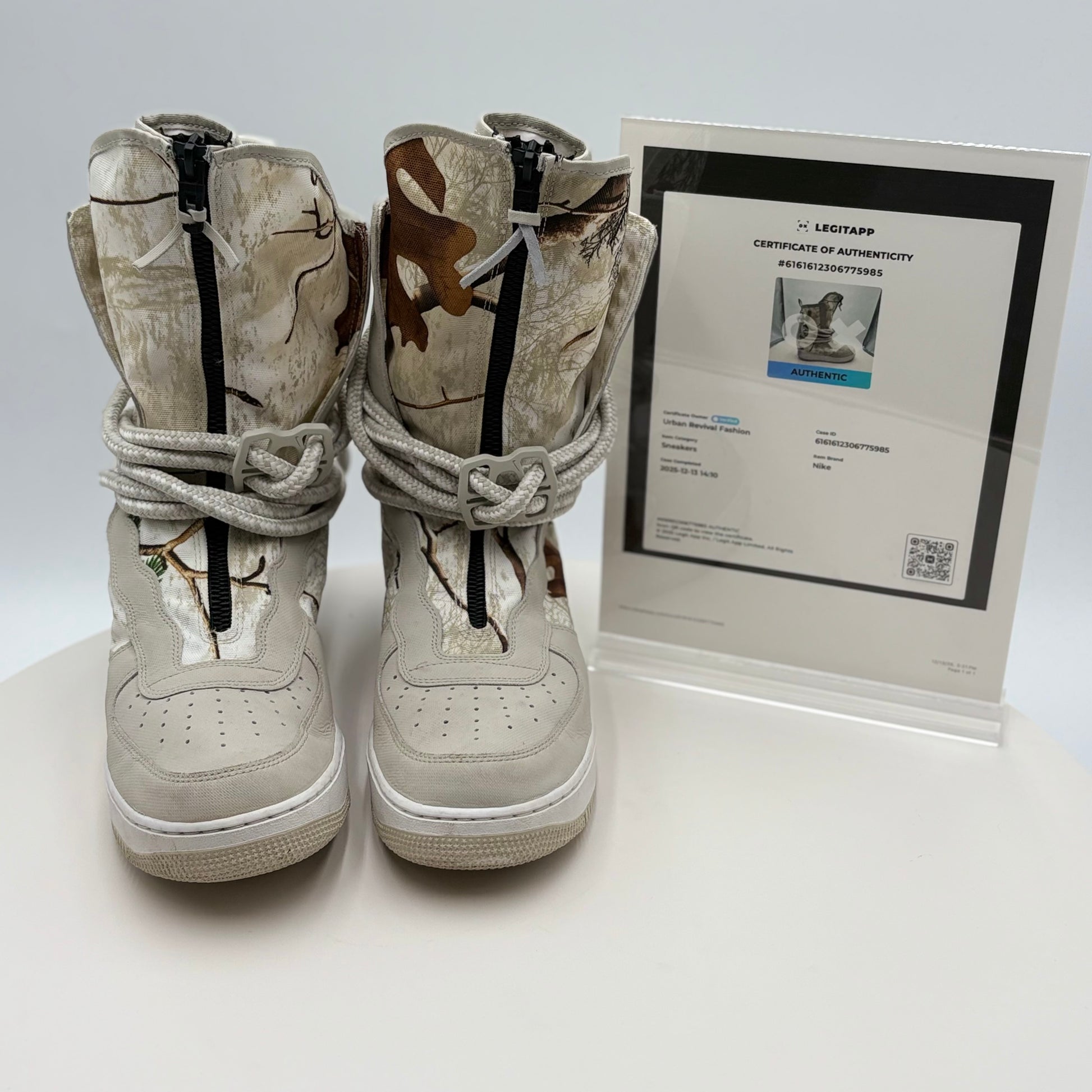 Pair of white high-top sneakers with a certificate of authenticity on a white background