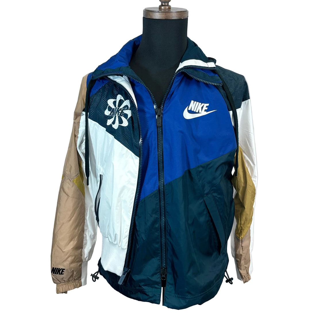 Multicolored jacket with Nike logos on a mannequin against a plain background