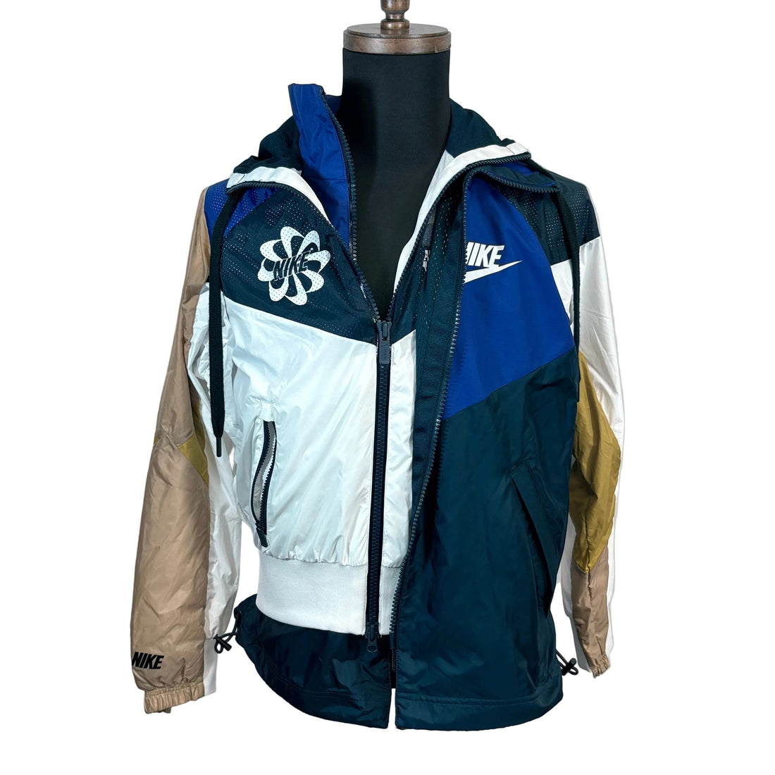 Multicolored jacket with Nike logos on a mannequin against a plain background
