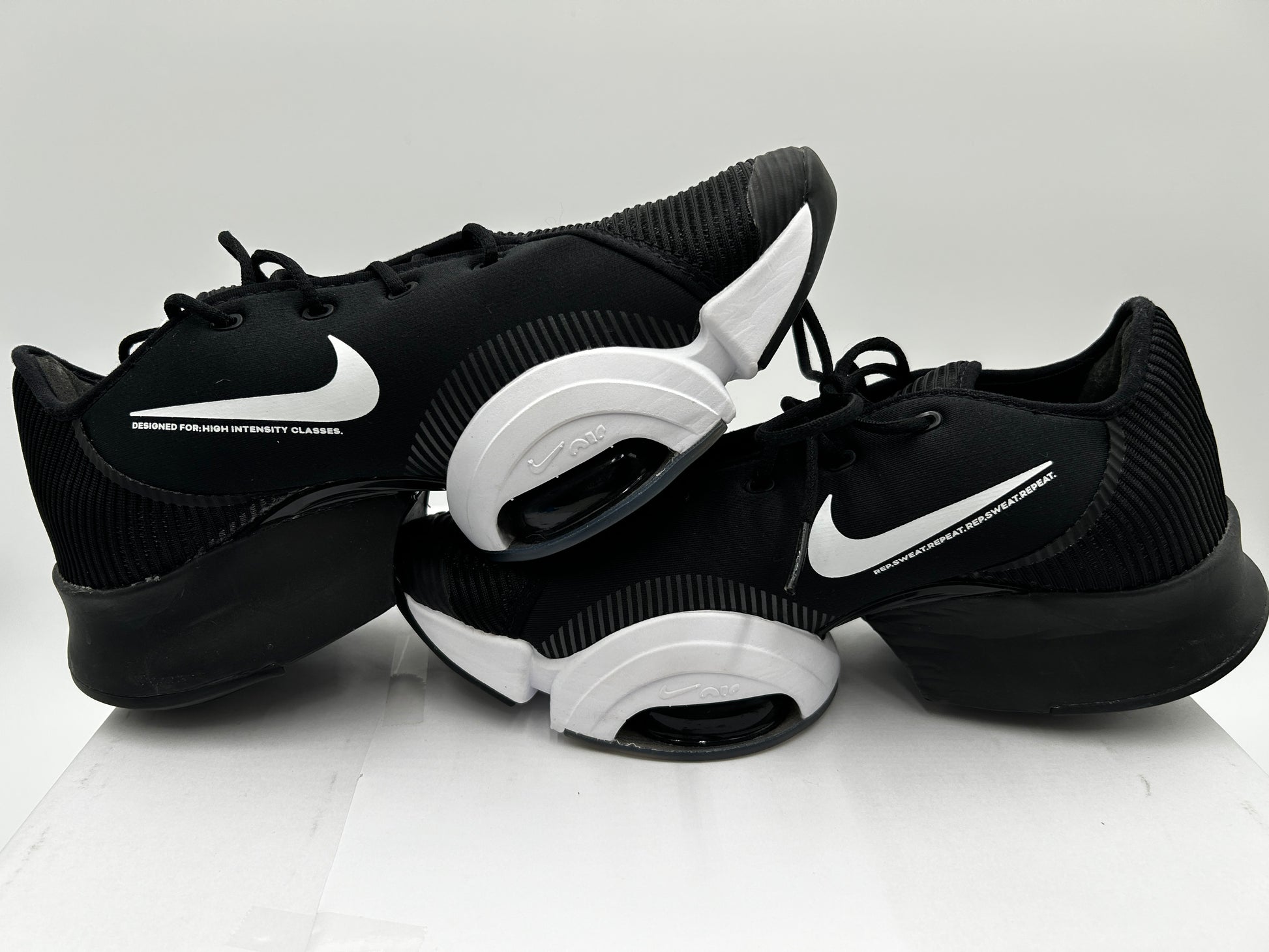Black and white sneakers with Nike logo on a light gray background