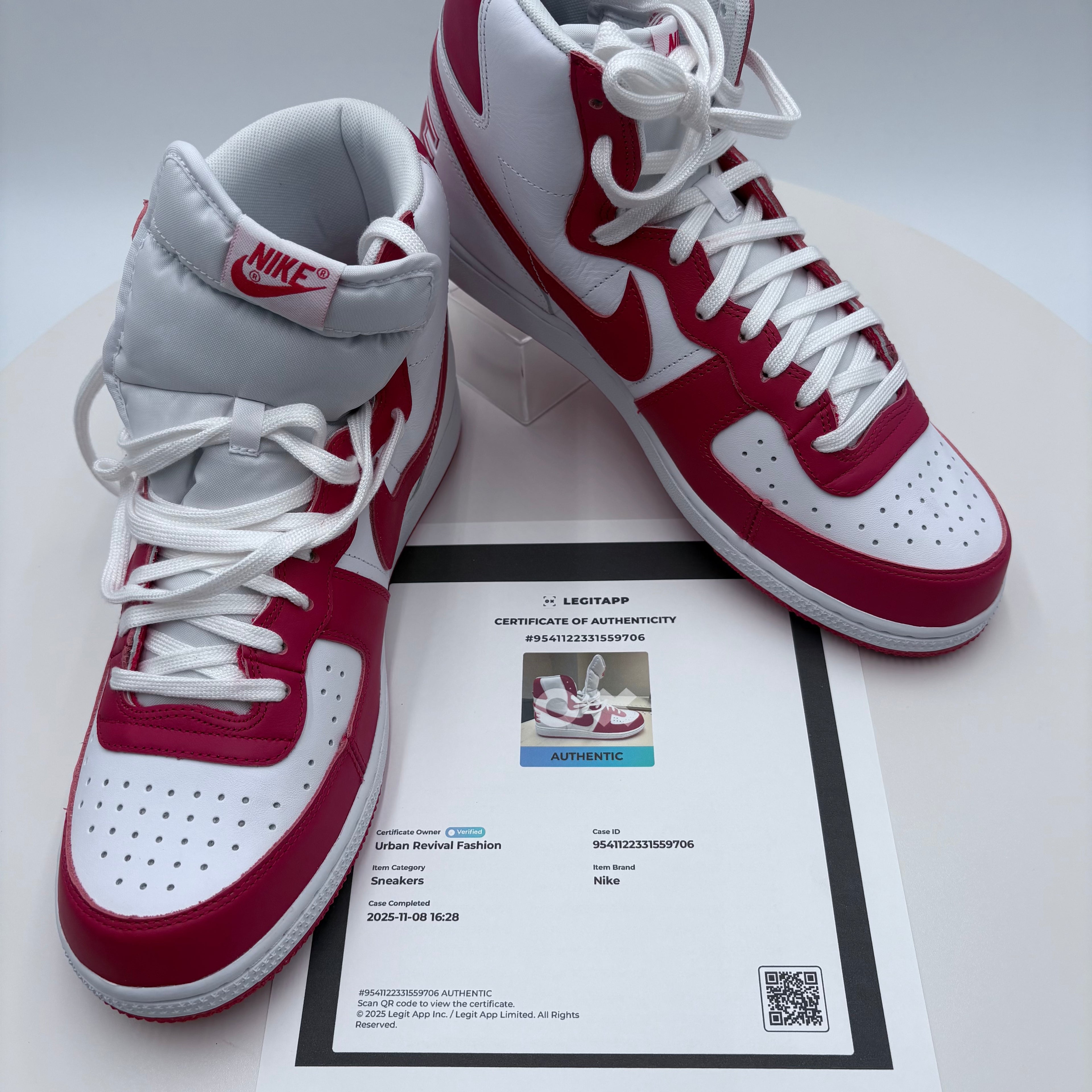 Red and white sneakers with a certificate of authenticity on a light gray background