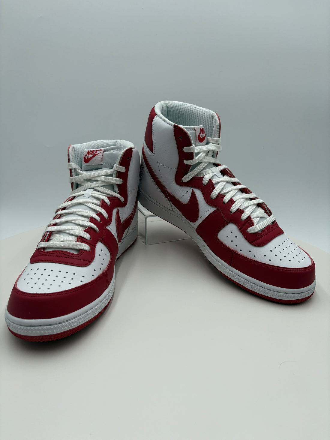 Red and white sneakers with a certificate of authenticity on a light gray background