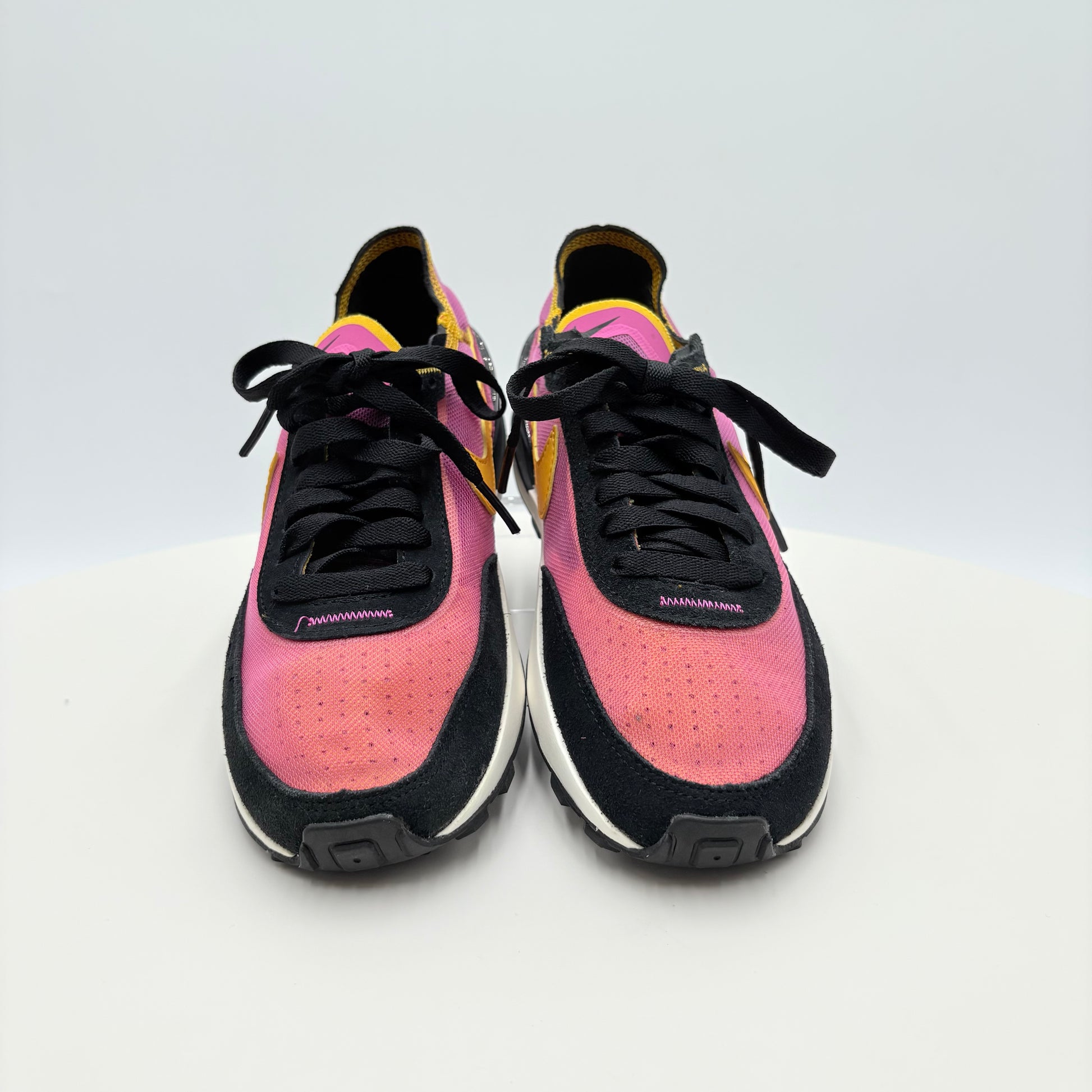 Pink and black sneakers on a white background