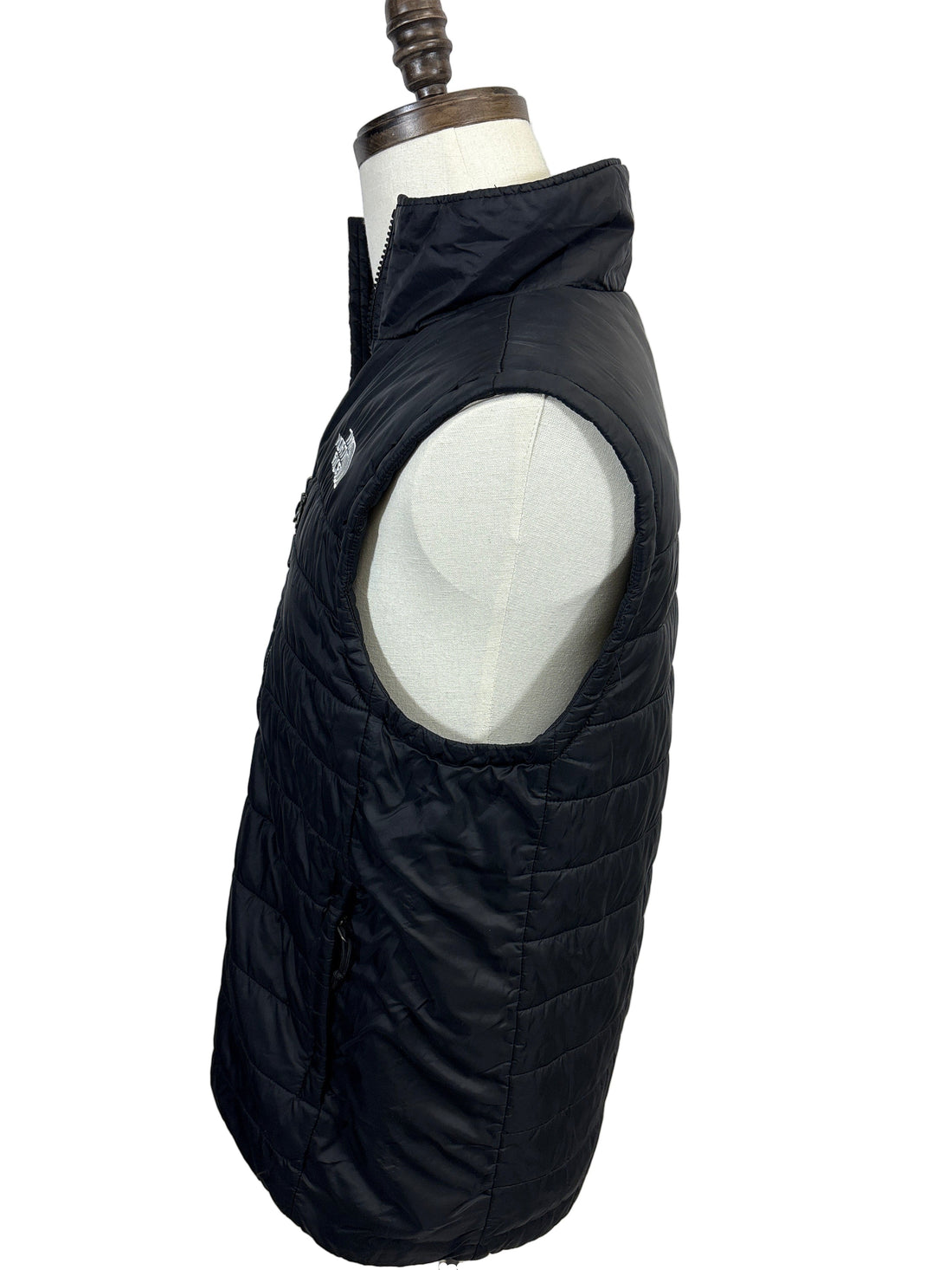 Black quilted jacket on a mannequin against a white background