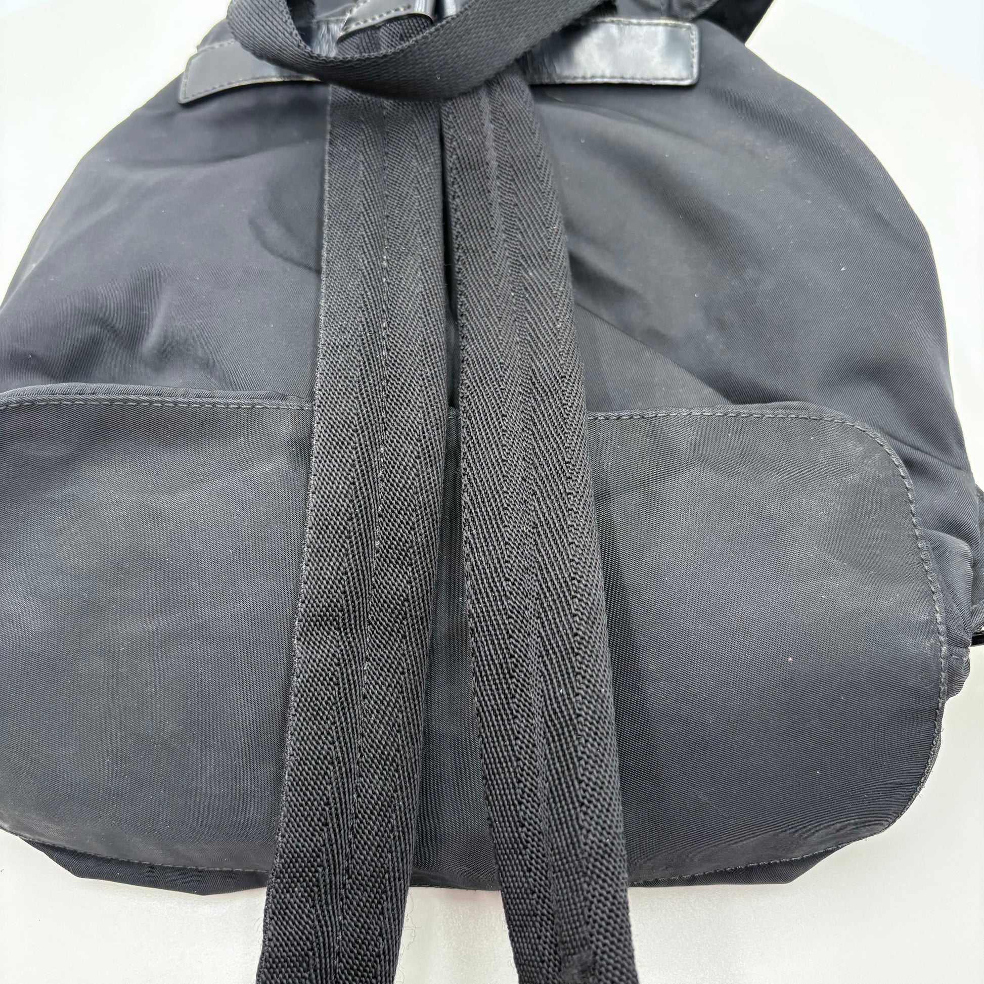 Black prada backpack with a black strap on a white background