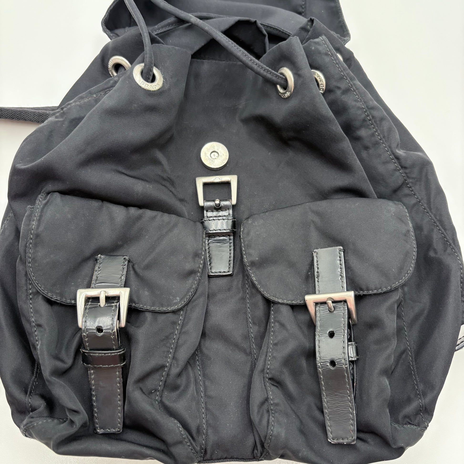 Dark gray backpack with leather straps on a light gray background